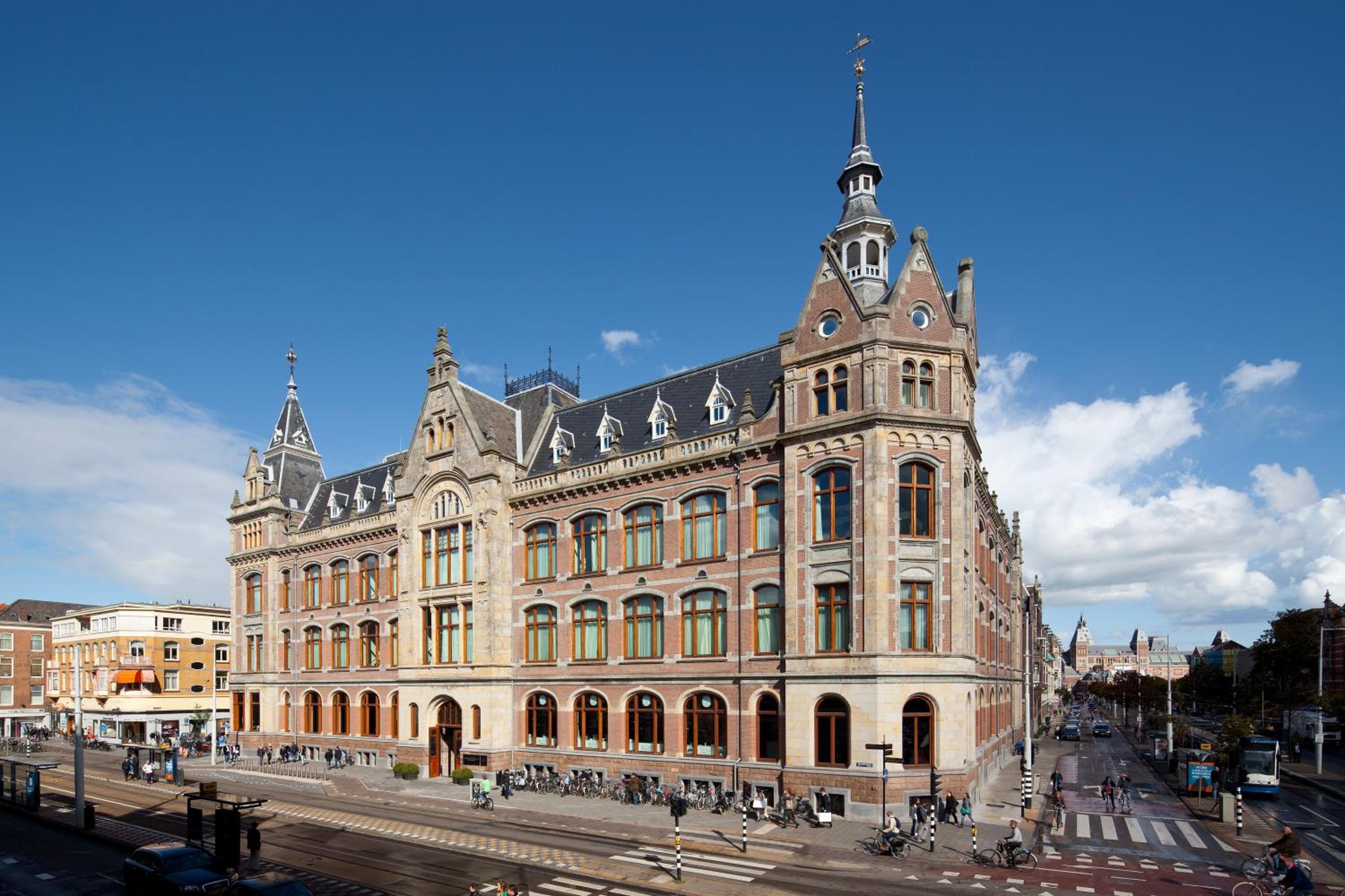 Amsterdam's striking red-brick Conservatorium rises majestically on Museumplein, its ornate 19th-century facade crowned with distinctive spires that pierce the Dutch sky.