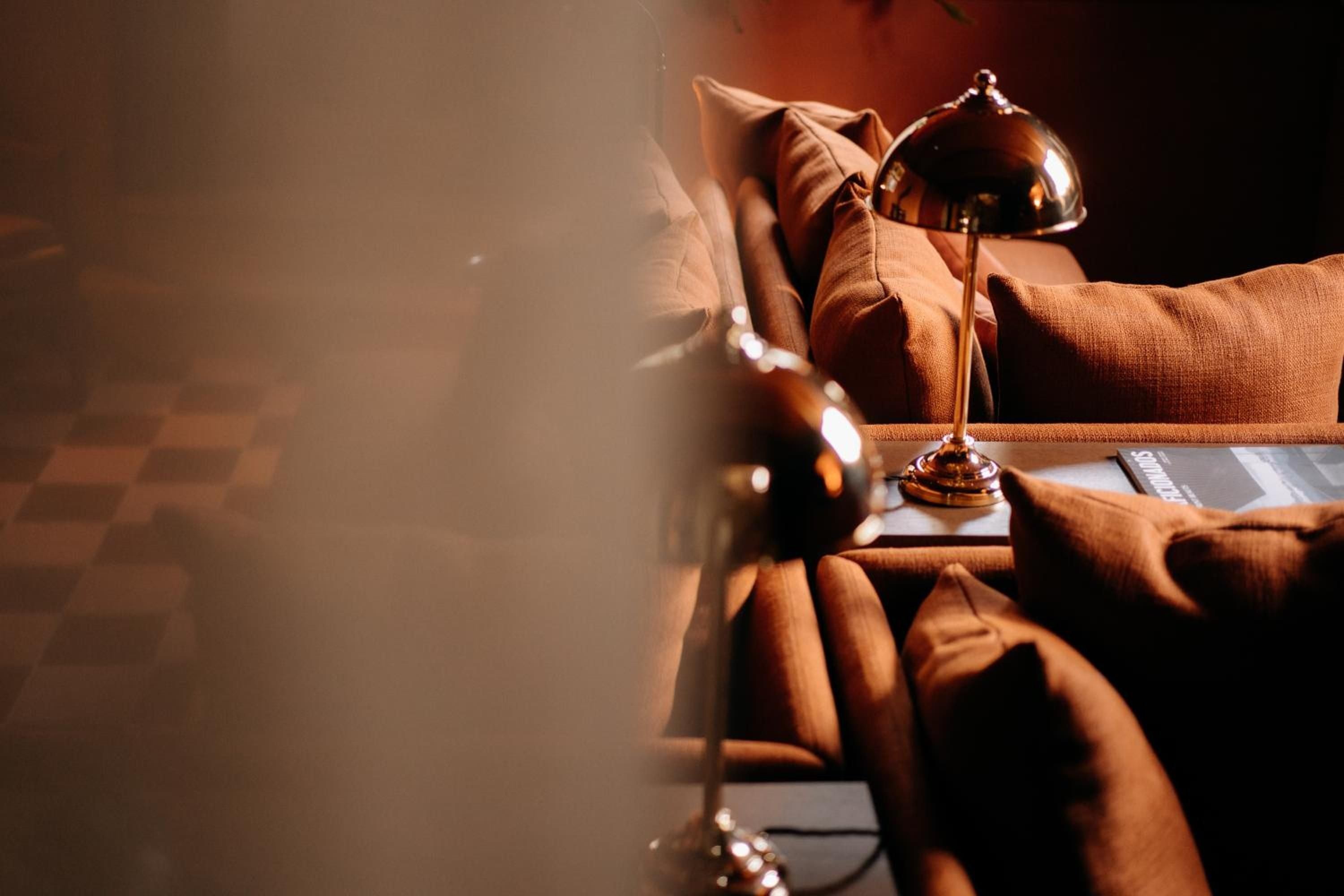 Golden afternoon light bathes plush amber recliners, where polished reading lamps cast an intimate glow across this serene wellness sanctuary.