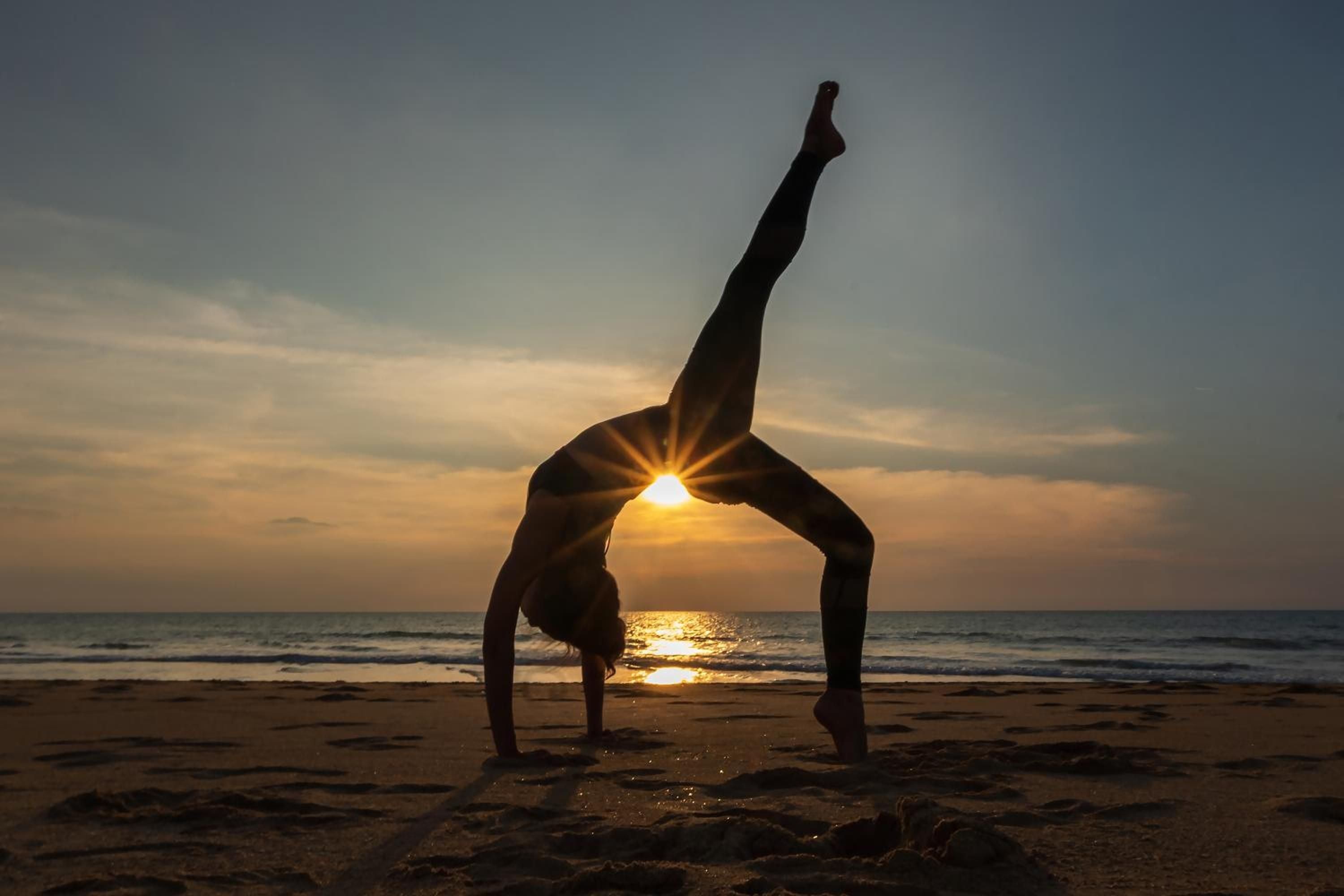 Golden hour transforms Khao Lak's pristine shoreline into nature's studio, where guests perfect their yoga practice as sunset rays pierce through graceful poses.