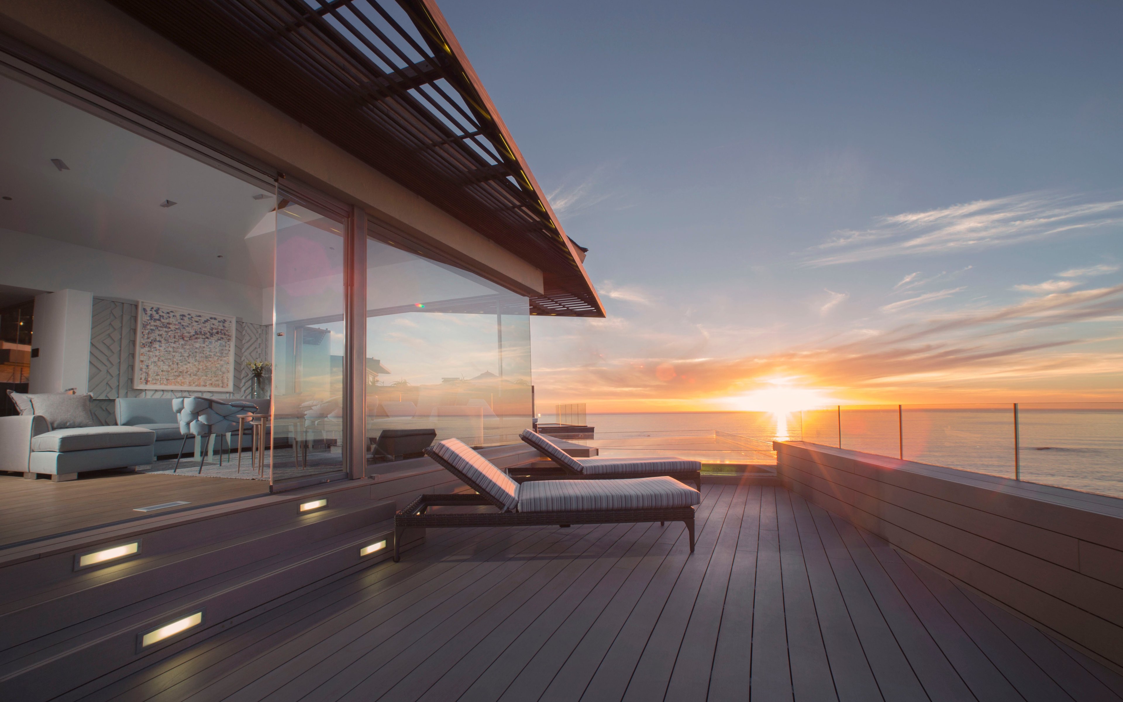 Sunset transforms Ellerman House's private deck into pure magic, where teak loungers face endless ocean views and golden light spills across every surface.