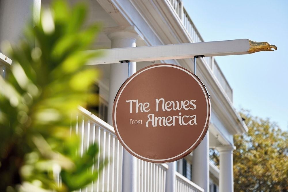 A charming wooden sign welcomes guests with island elegance, its warm brown tones echoing the Vineyard's earthy palette against classic white clapboard architecture.