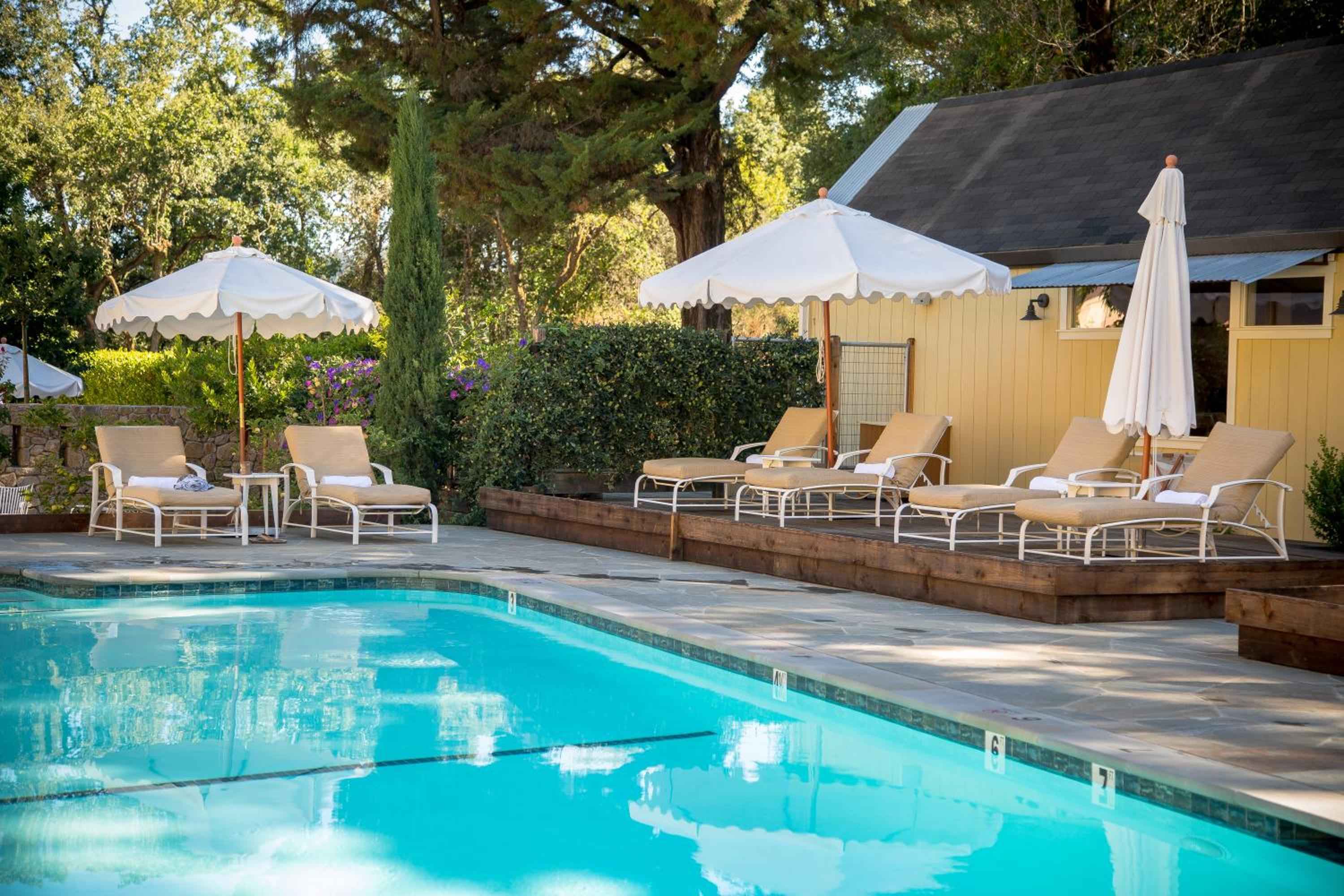 Sun-dappled poolside loungers beckon beneath scalloped umbrellas, while manicured hedgerows frame this serene aquatic retreat at wine country's most intimate escape.