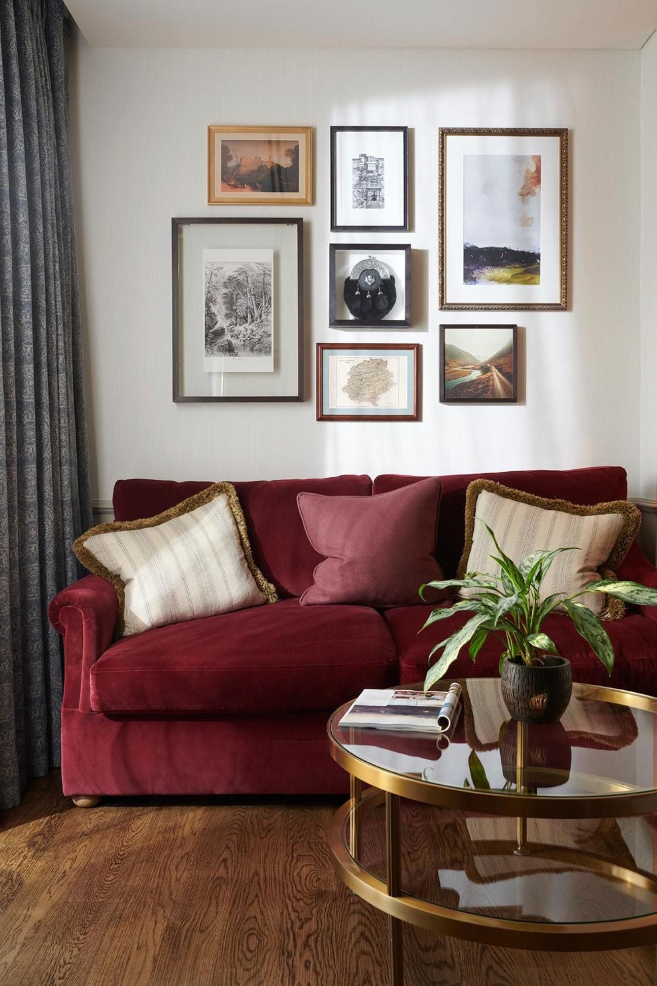 Burgundy velvet embraces guests in this intimate sitting area, where thoughtfully curated artwork and brass-accented furnishings create an atmosphere of refined Scottish elegance.