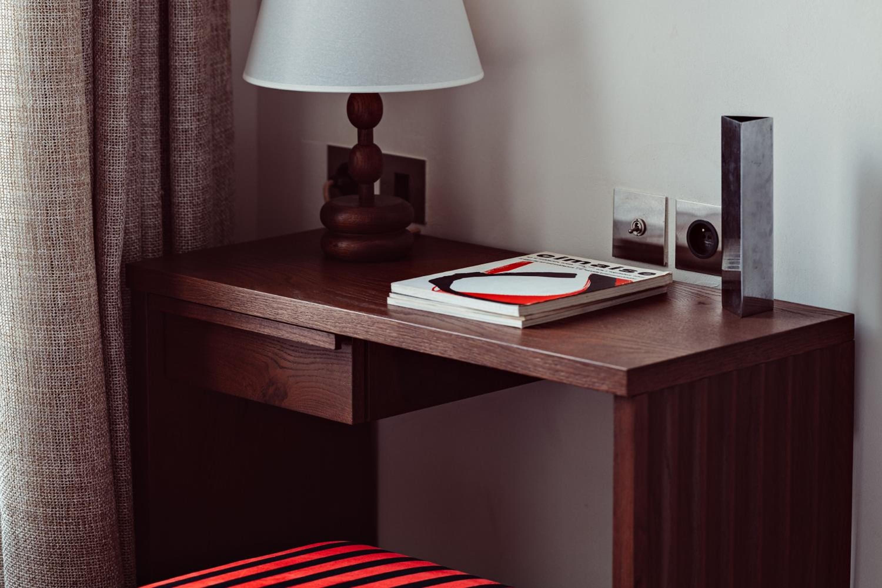 Warm walnut surfaces and thoughtful details create an intimate workspace where morning coffee meets leather-bound journals beneath soft lamplight.