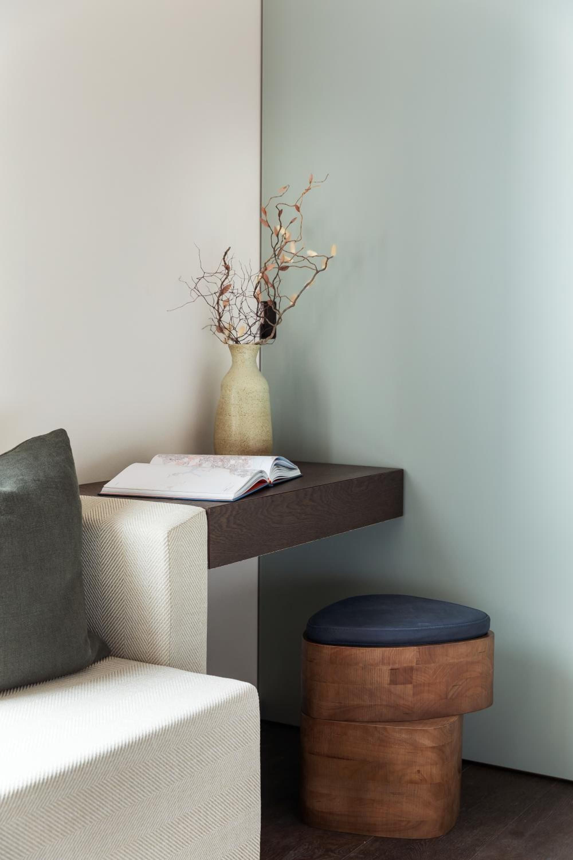 Thoughtfully curated corners blend warm timber textures with sage-green walls, where dried botanicals and artisanal ceramics create intimate moments of quiet sophistication.