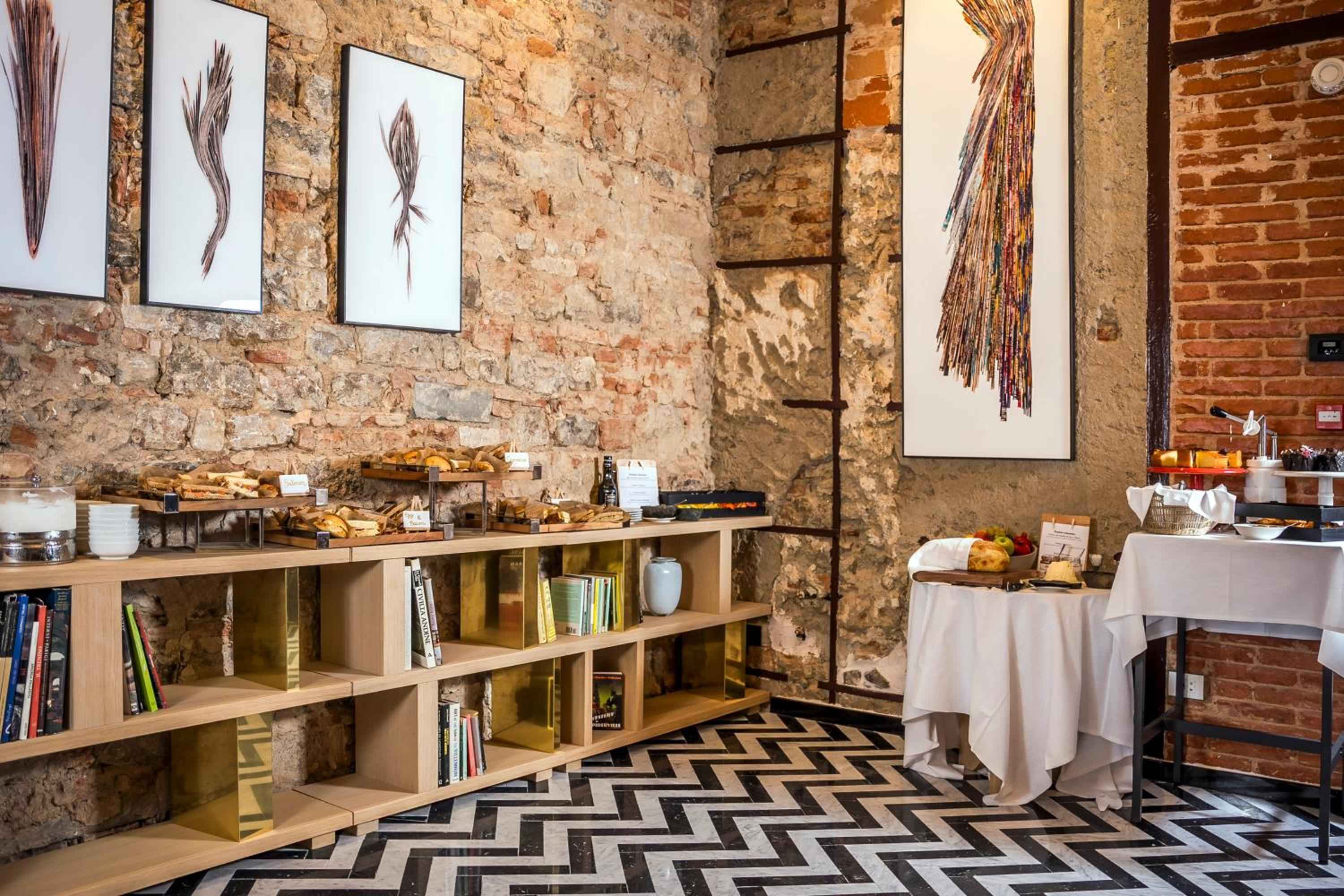 Rustic stone walls frame a continental breakfast spread where artisanal breads and local preserves invite lingering morning conversations beneath botanical prints.
