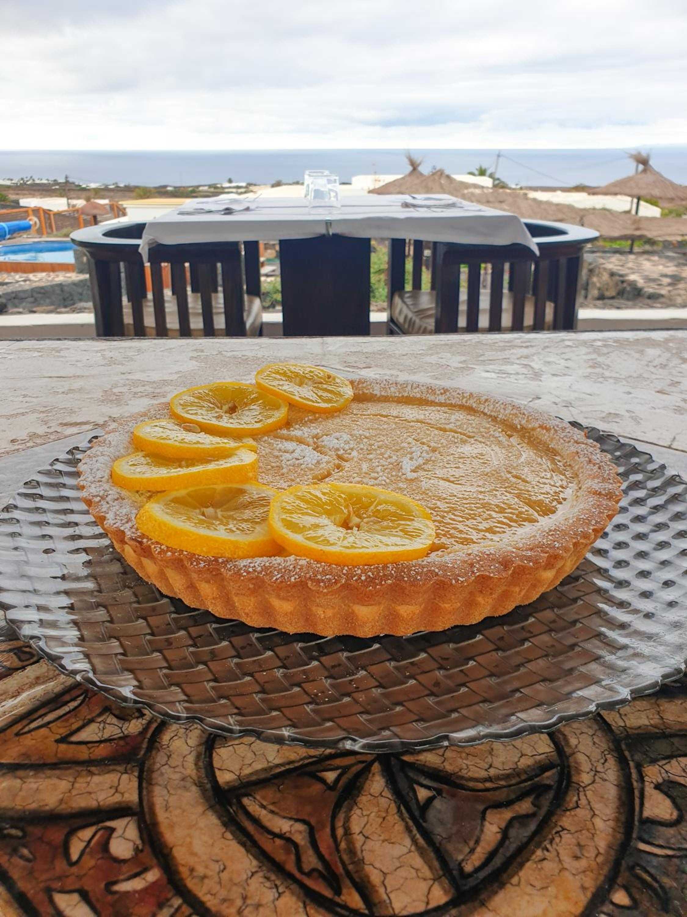 Orange-scented cake adorned with candied citrus slices captures the essence of island dining, served oceanside where Atlantic breezes meet volcanic stone terraces.