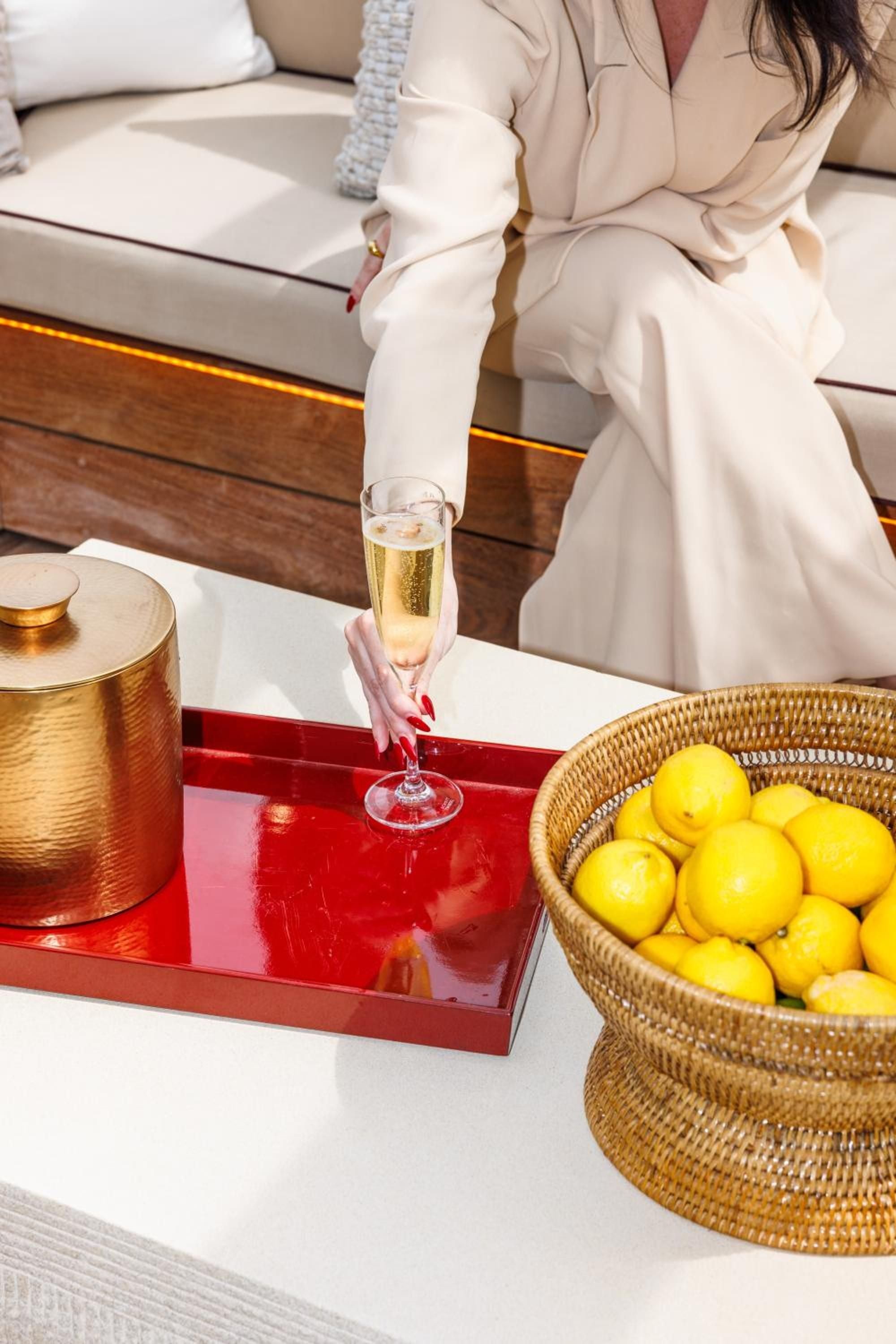 Champagne bubbles catch afternoon light while golden citrus spills from a woven basket—intimate luxuries that define Manhattan's most coveted hospitality moments.