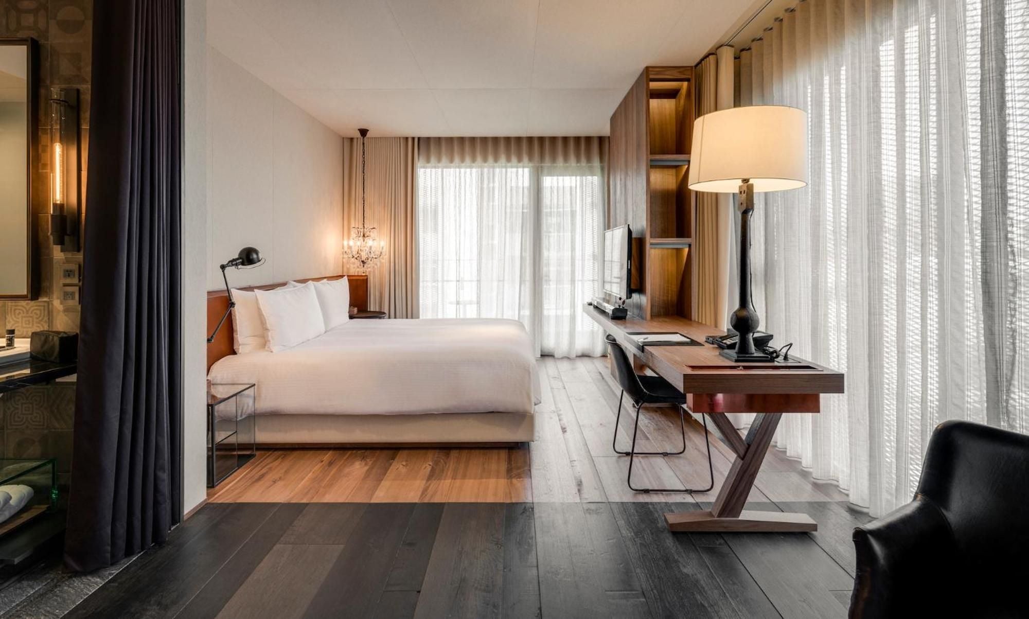 Warm wood tones and contemporary furnishings create an inviting sanctuary, where floor-to-ceiling windows bathe the thoughtfully designed space in gentle natural light.