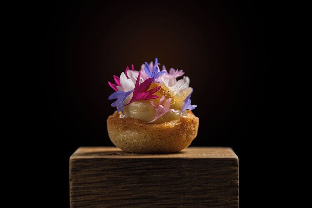 Delicate edible flowers crown an artisanal creation, showcasing the restaurant's commitment to culinary artistry where every dish becomes a carefully composed masterpiece.