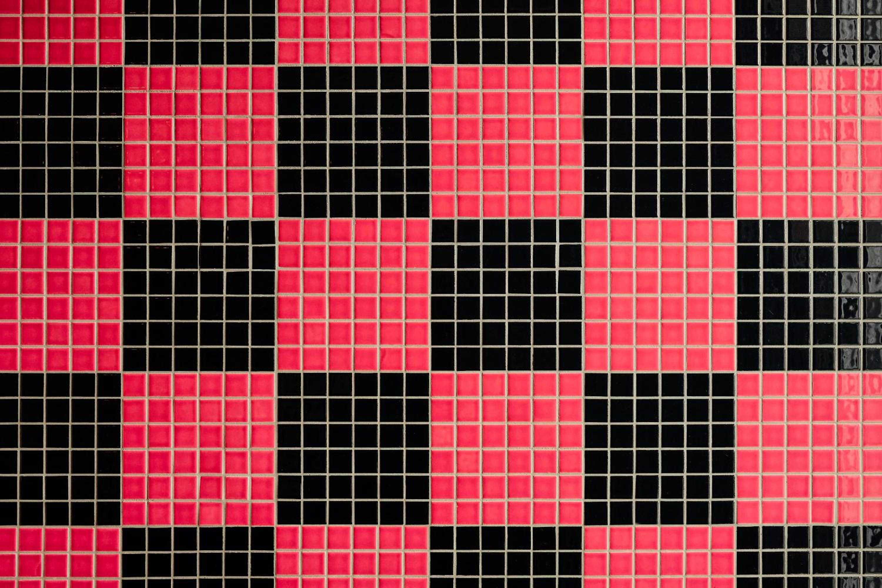 Vibrant red and black mosaic tiles create a bold checkerboard pattern, transforming functional surfaces into striking geometric art that pulses with contemporary energy.