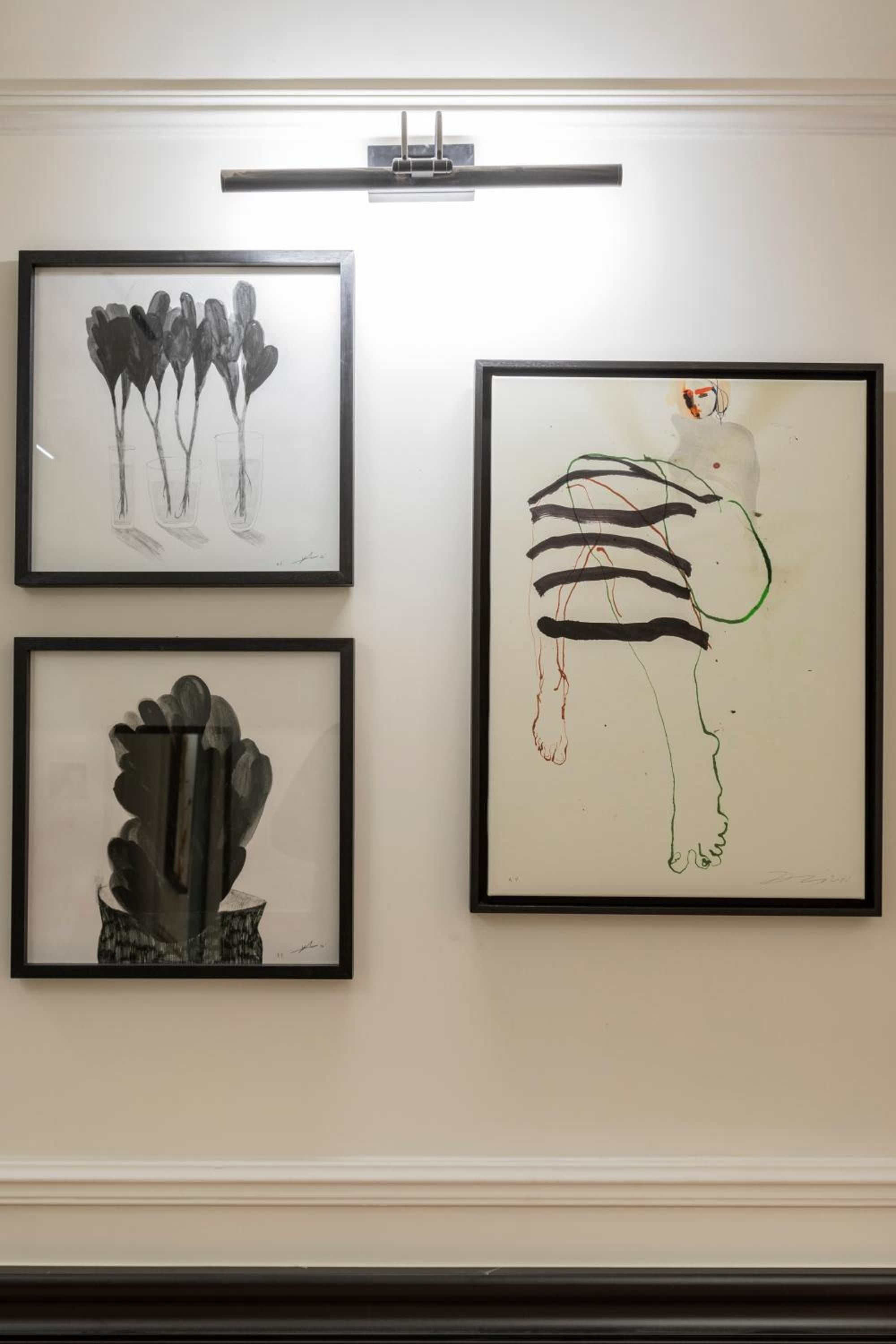 Thoughtfully curated artwork adorns intimate gallery walls, where contemporary sketches and abstract forms create a sophisticated cultural backdrop illuminated by sleek picture lighting.