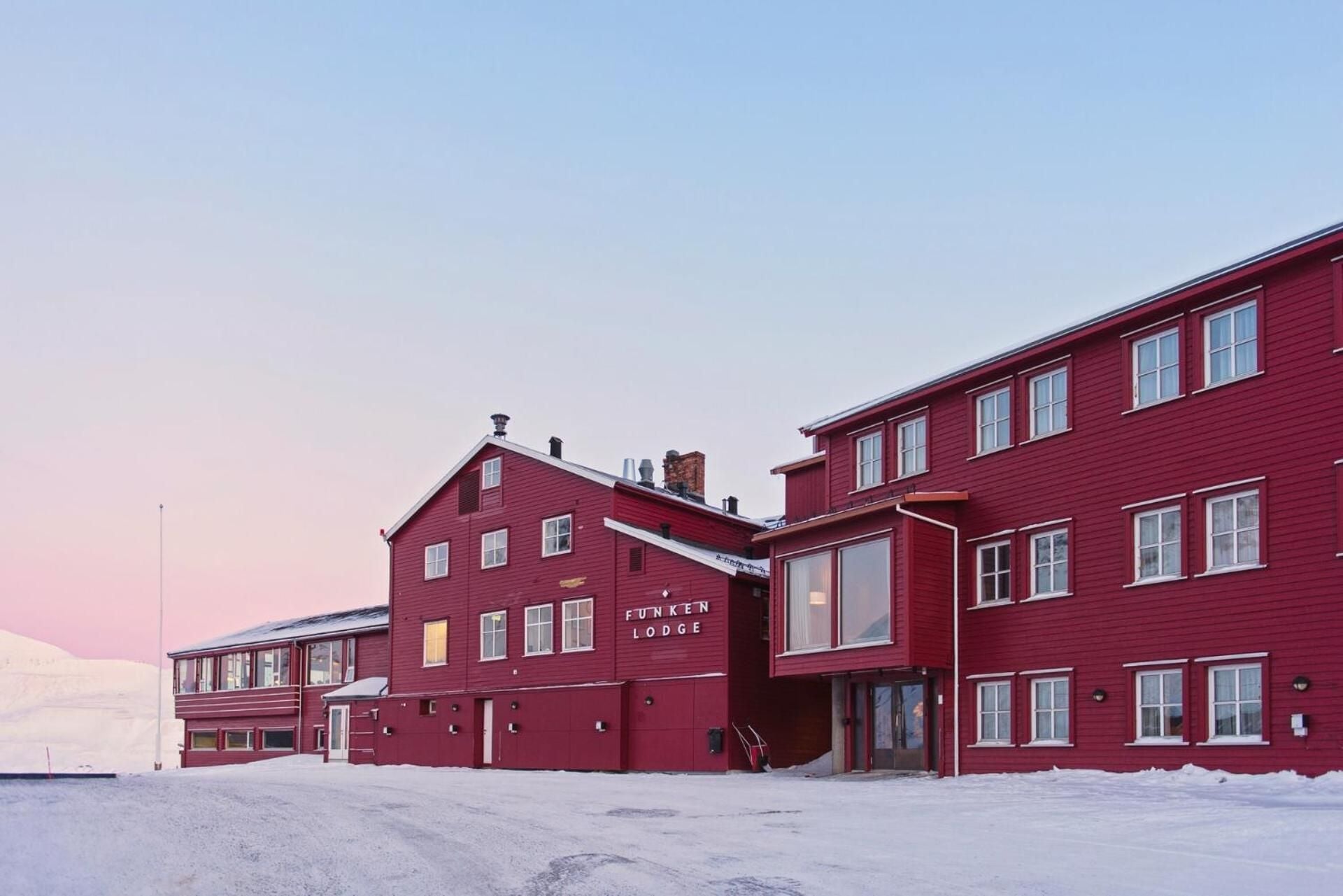 Where the northern light meets warm timber on Svalbard's frozen shore in Longyearbyen, Svalbard