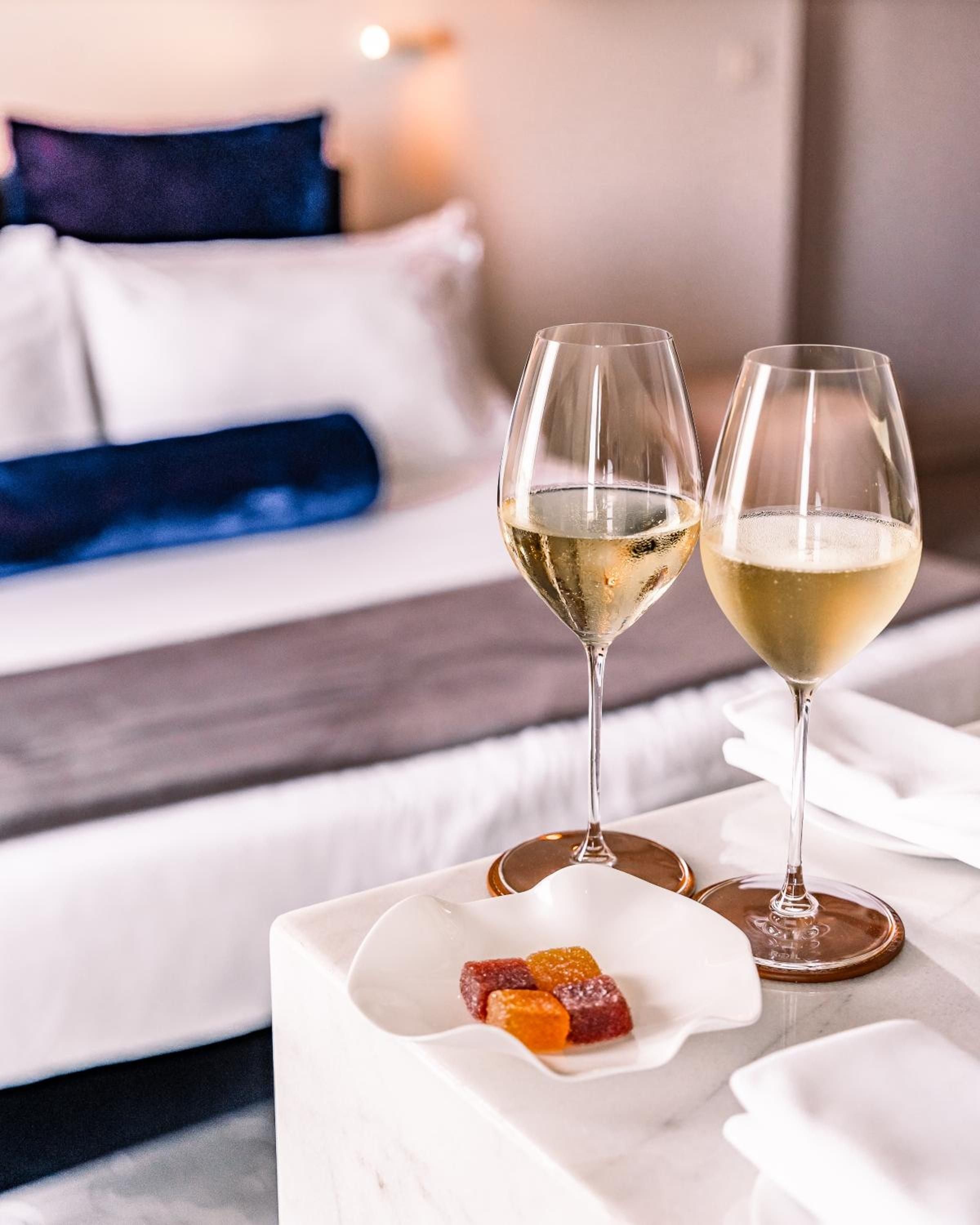 Champagne bubbles catch golden light beside jewel-toned confections, transforming an intimate room into a stage for life's sweetest celebrations.