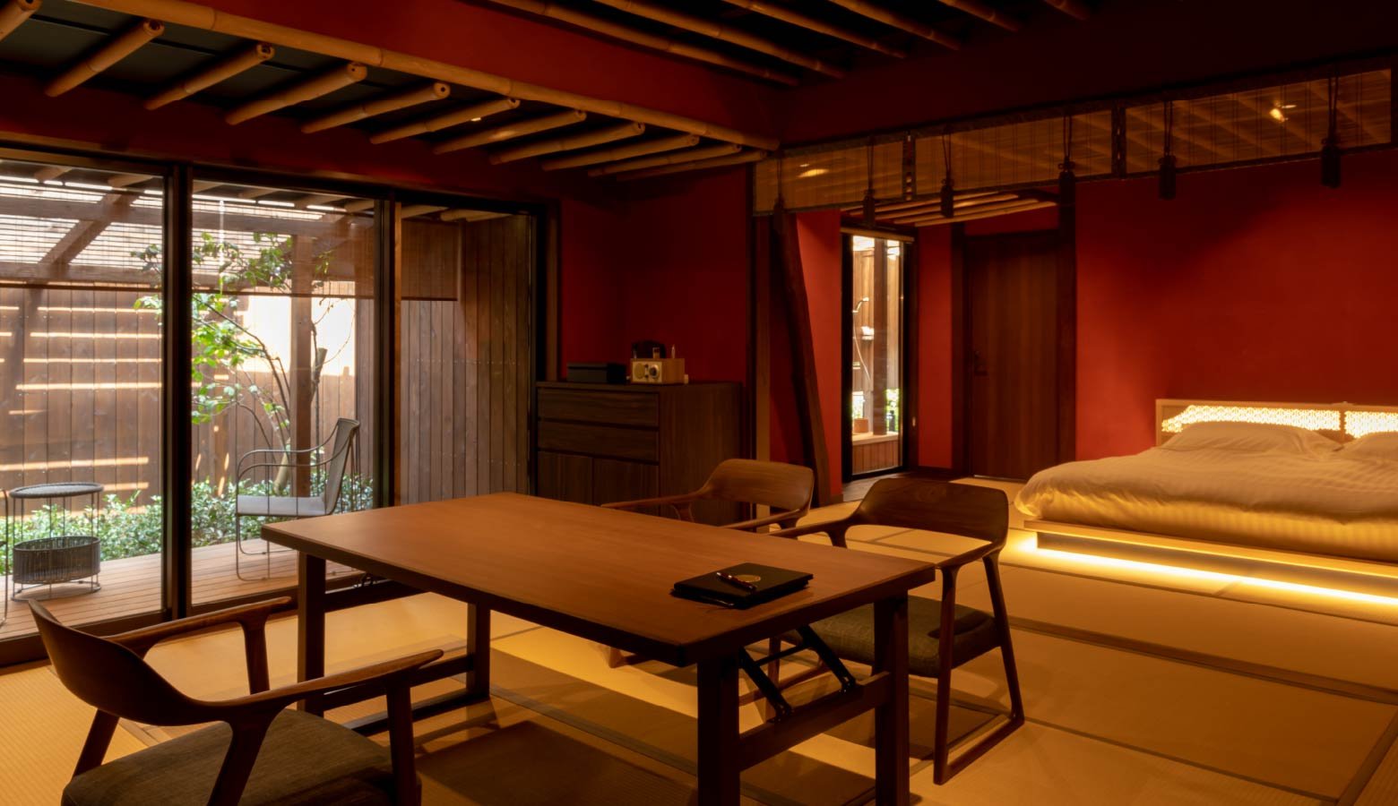Warm amber light bathes the minimalist suite where tatami meets contemporary design, creating an intimate sanctuary that perfectly balances traditional Japanese aesthetics with modern luxury.