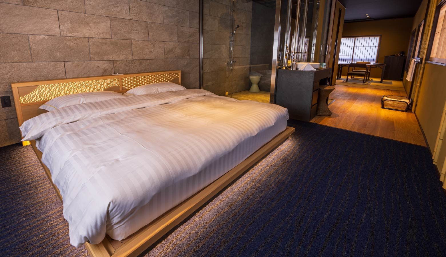 Geometric woodwork headboards and soft ambient lighting create an intimate sanctuary where modern Japanese design meets luxurious comfort in this elevated sleeping space.