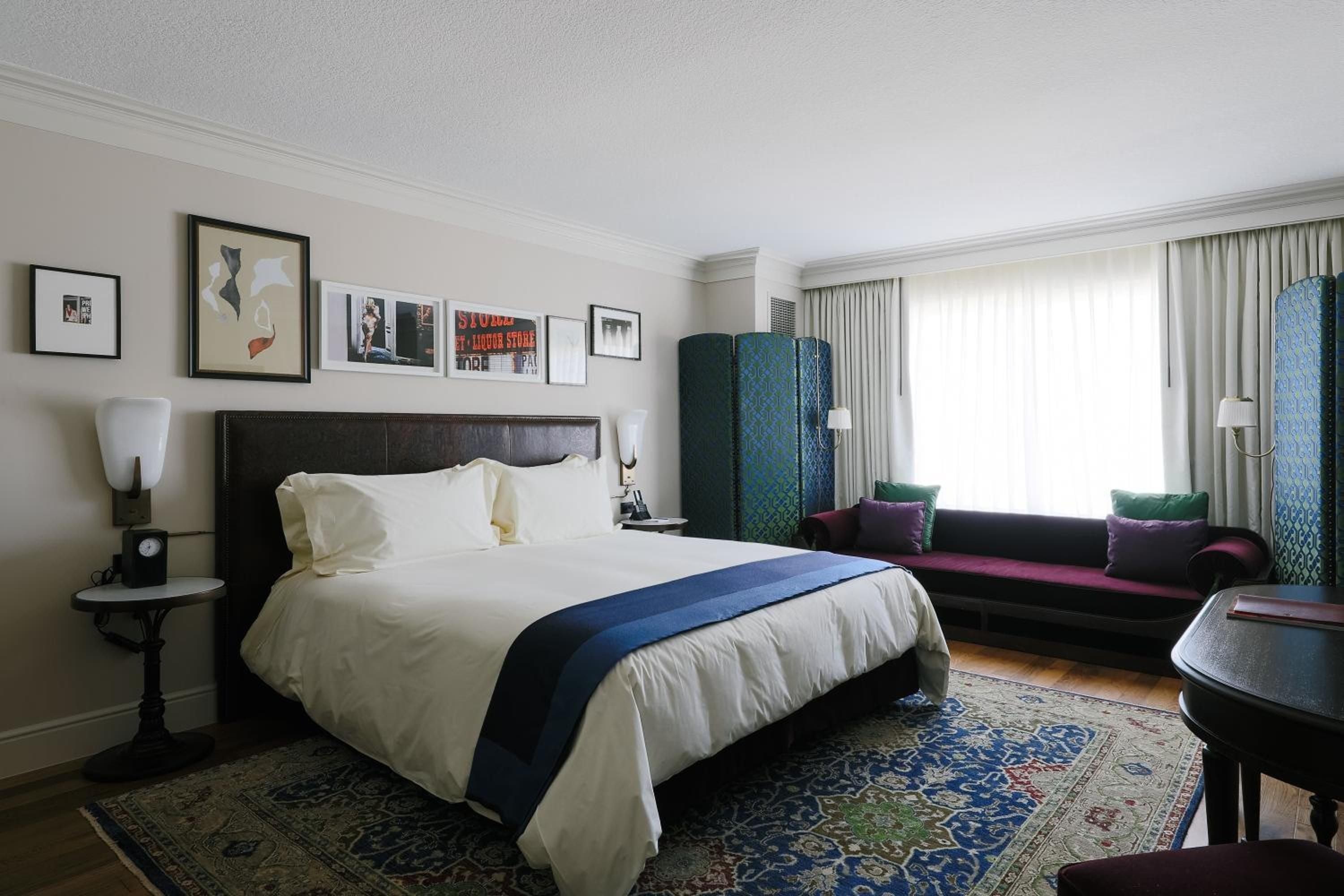Jewel-toned furnishings and curated artwork create an intimate sanctuary, where plush velvet seating and ornate Persian rugs transform this spacious suite into a sophisticated urban retreat.