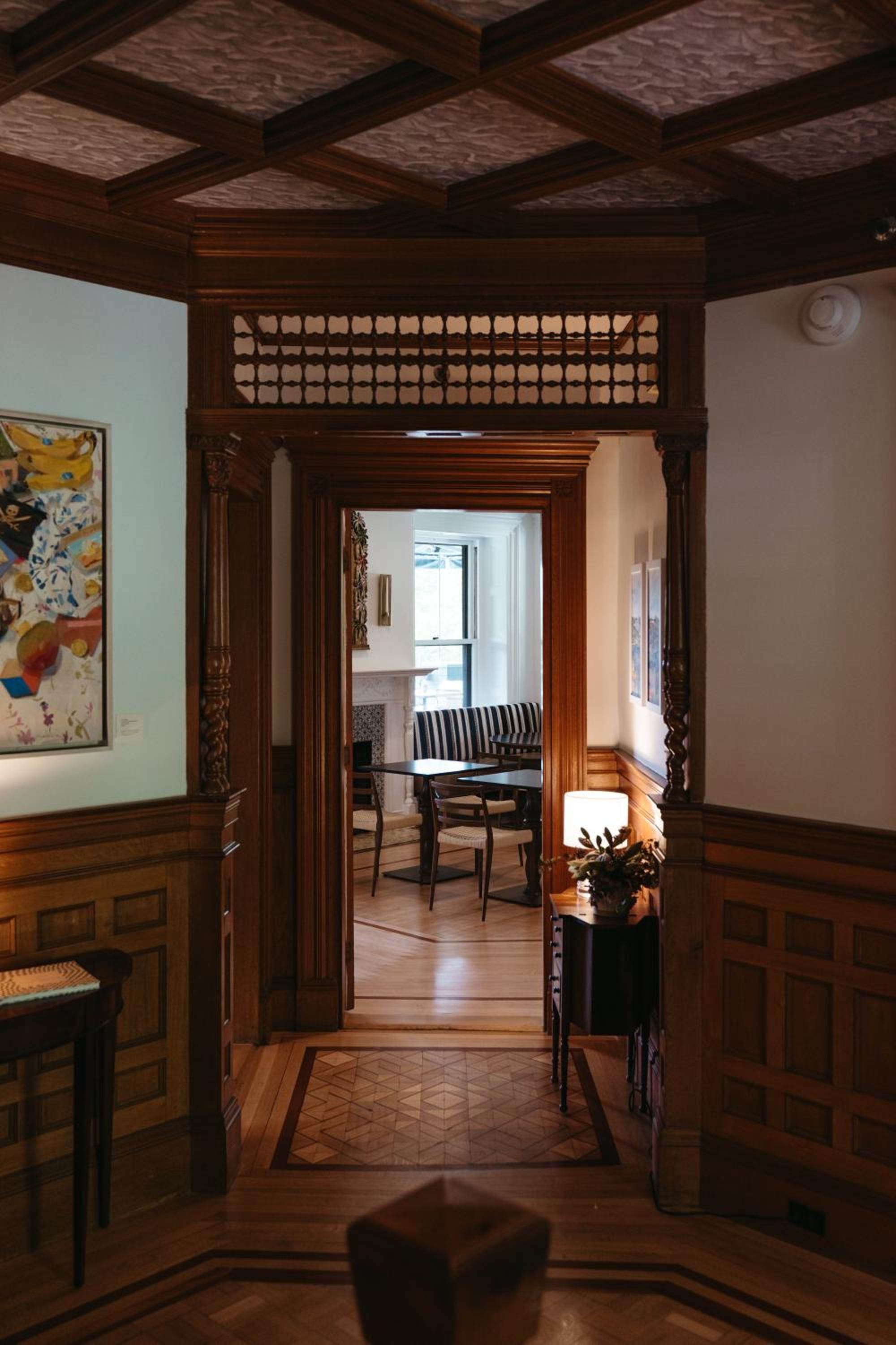 Rich mahogany millwork frames intimate passageways where coffered ceilings and intricate woodwork create a sense of old-world grandeur and timeless craftsmanship.