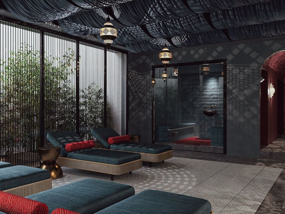 Moroccan-inspired lanterns cast intricate shadows across charcoal walls while teak daybeds invite contemplation in this serene wellness sanctuary.