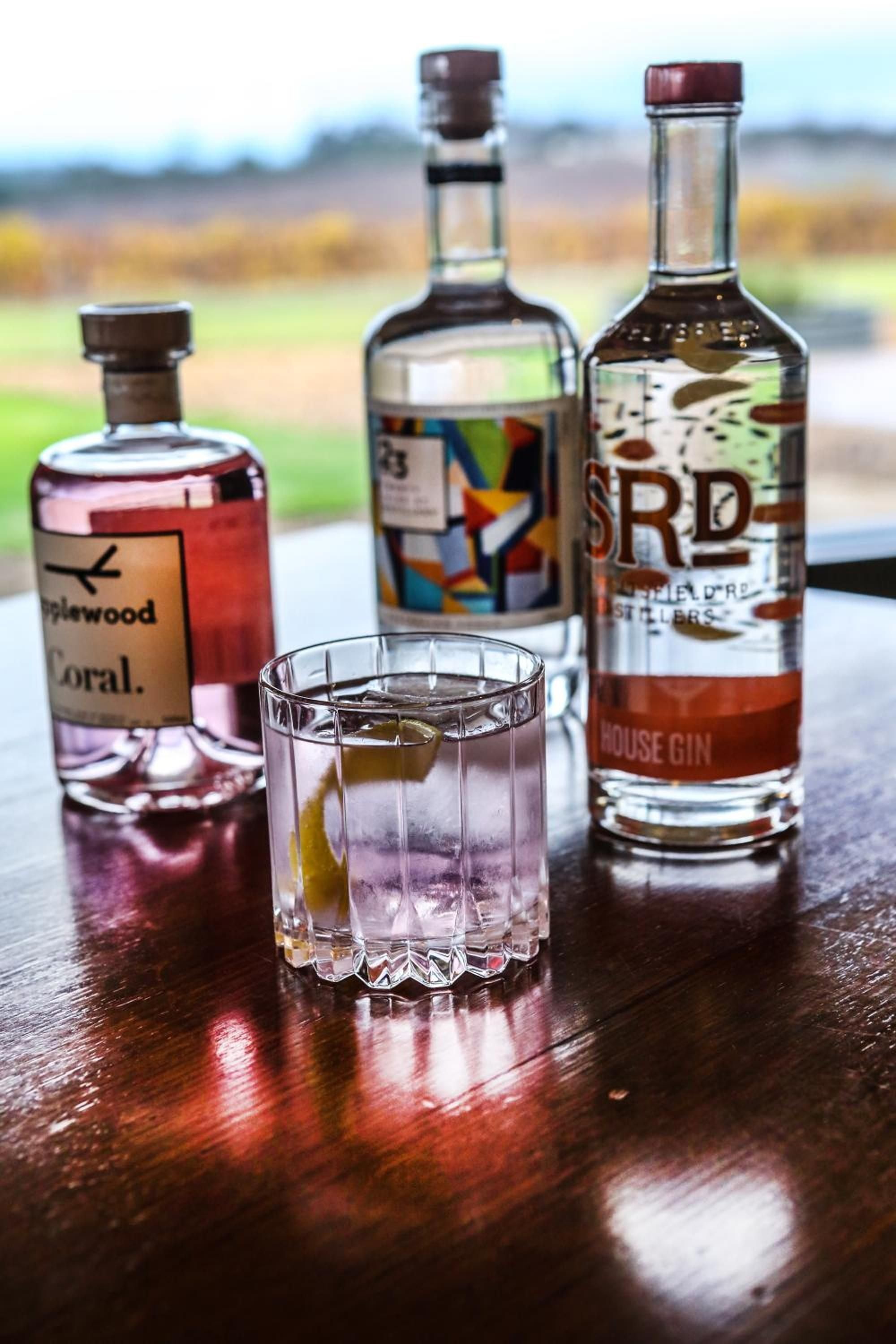 Craft spirits line the bar at The Louise, where local gins and artisanal bottles create an intimate tasting experience against the Barossa Valley's golden afternoon light.