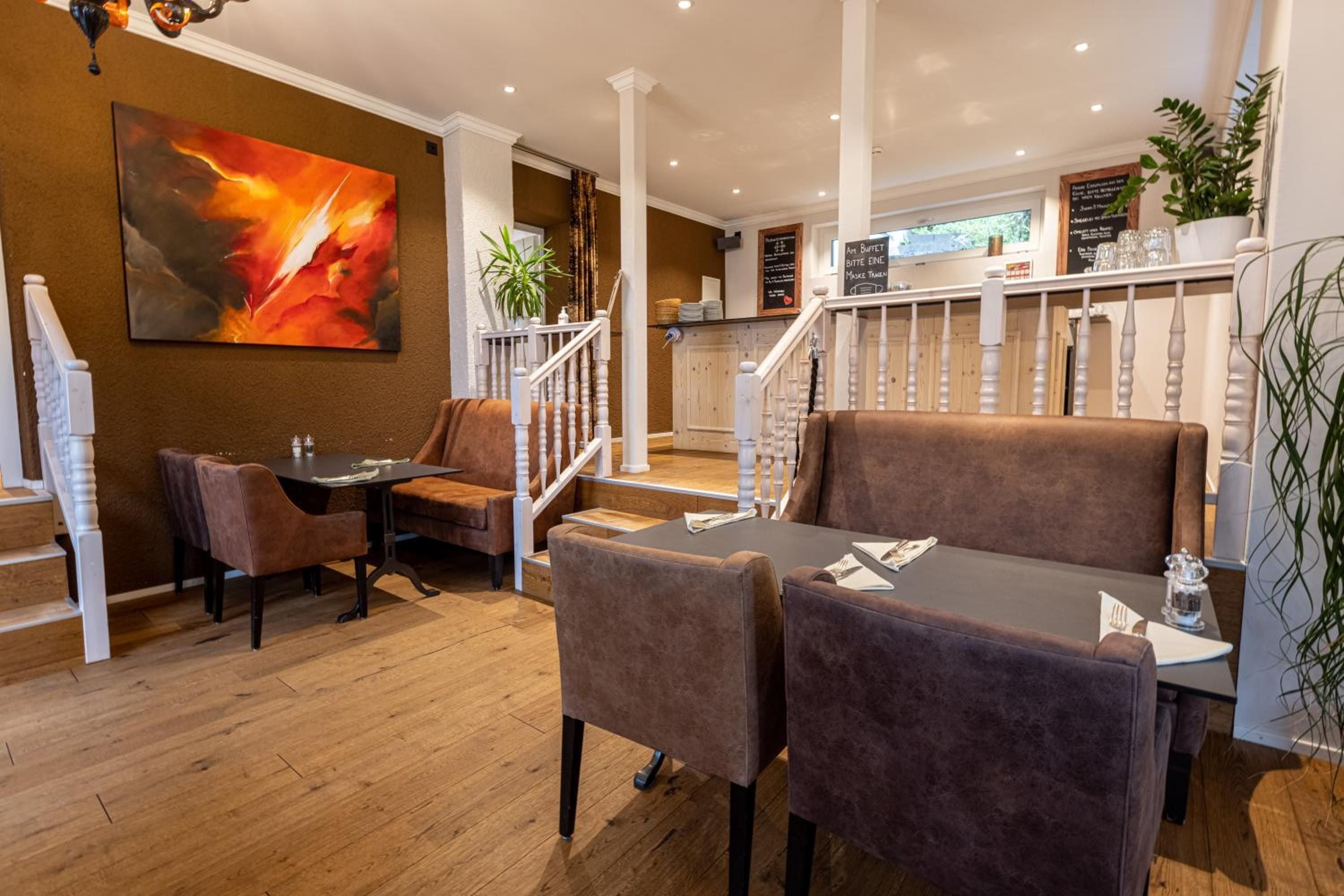 Warm amber lighting and rich chocolate leather banquettes create an inviting mountain bistro atmosphere, where rustic wooden floors meet contemporary comfort in perfect alpine harmony.