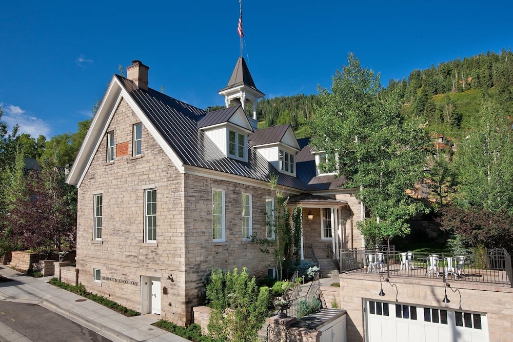 Historic sandstone walls and distinctive cupola create an enchanting Alpine setting, where this former 1889 schoolhouse stands majestically against Park City's forested mountainside.