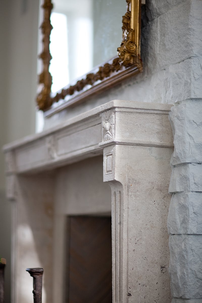 Hand-carved limestone details and gilded mirror frames reveal the meticulous craftsmanship that transformed this 1889 schoolhouse into an intimate luxury retreat.