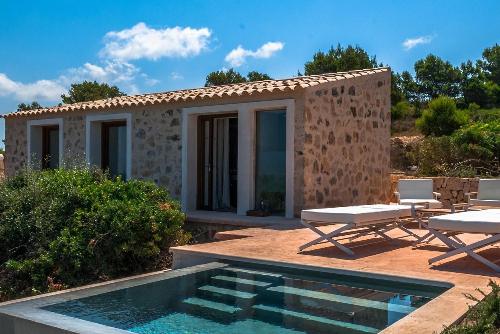 Natural stone walls and terracotta tiles frame this intimate pool suite, where Mallorcan craftsmanship meets modern luxury beneath the Mediterranean sun.
