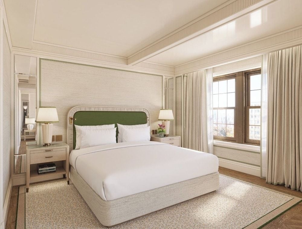 Soft morning light filters through floor-to-ceiling windows, illuminating the sophisticated neutral palette and emerald velvet headboard that anchors this serene Upper East Side sanctuary.