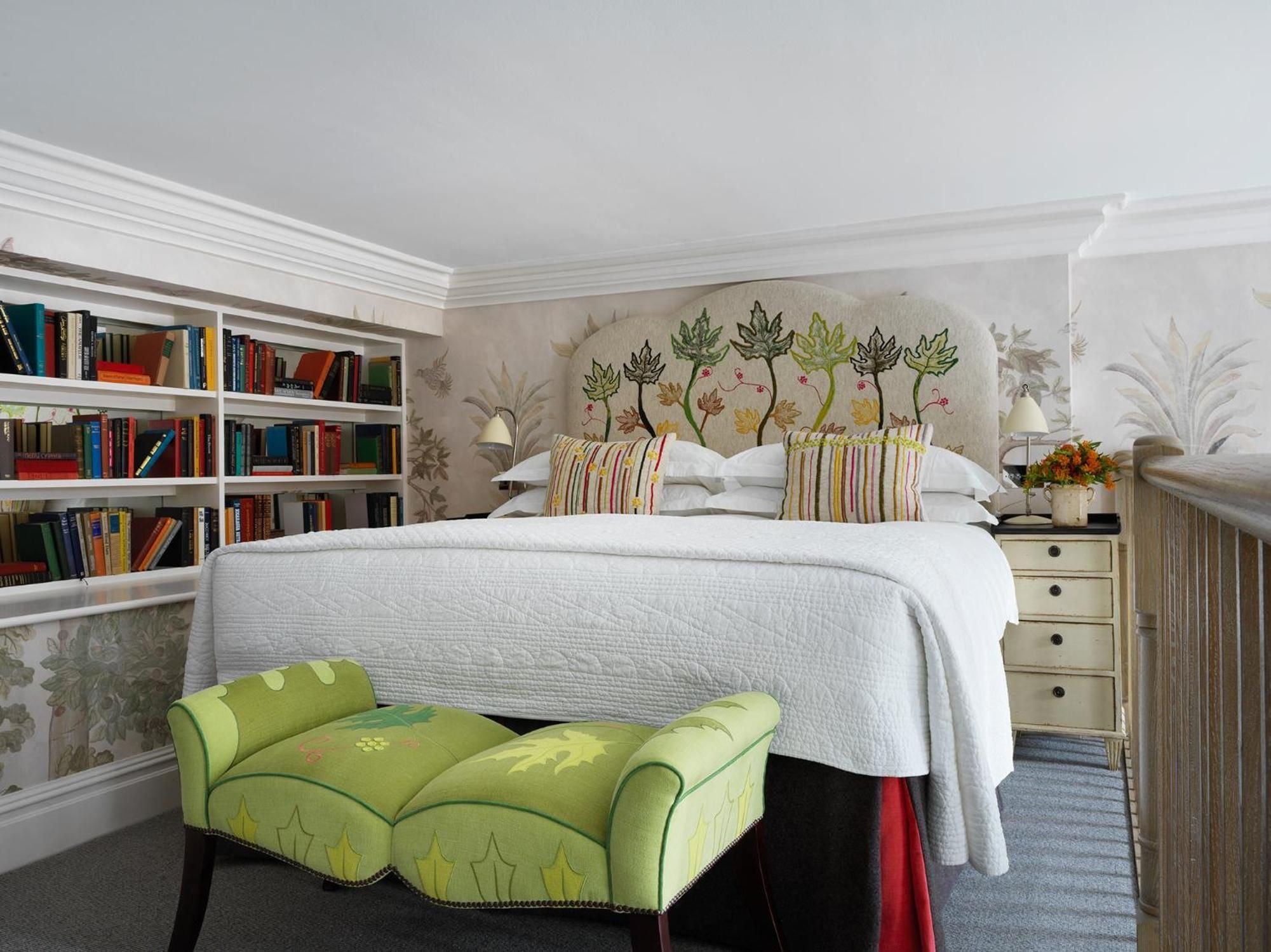 Hand-painted botanical wallpaper and emerald velvet create an intimate reading nook, while floor-to-ceiling bookshelves transform this suite into a literary sanctuary.