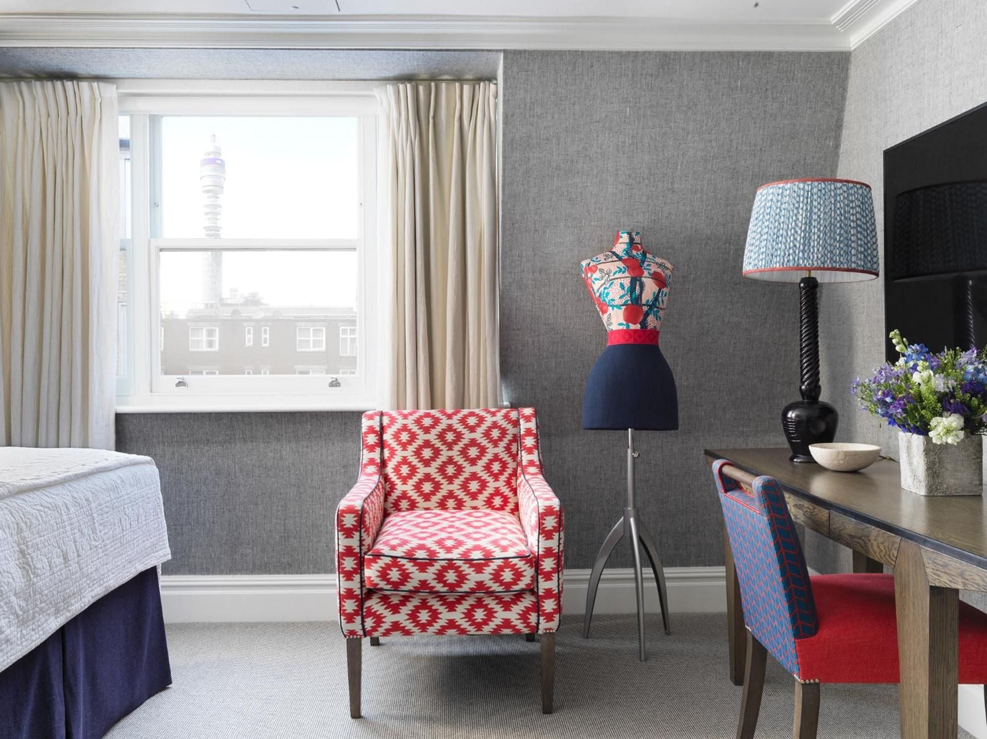 Bold geometric patterns and navy accents create a distinctly British charm in this thoughtfully appointed guest room, where tailored fabrics meet contemporary London style.