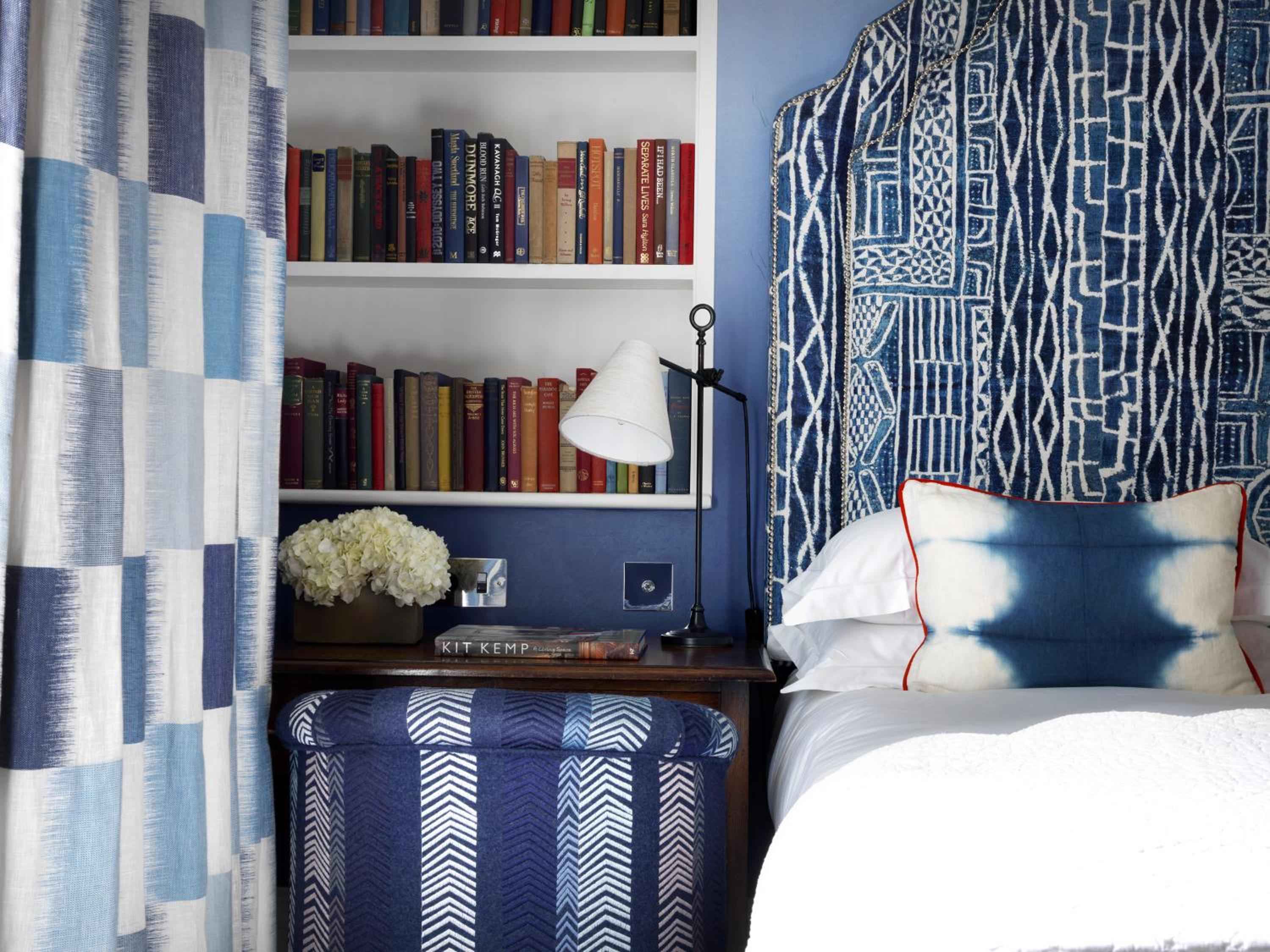 Blue and white patterns dance across every surface in this cozy reading nook, where built-in bookshelves and geometric textiles create an intimate literary retreat.