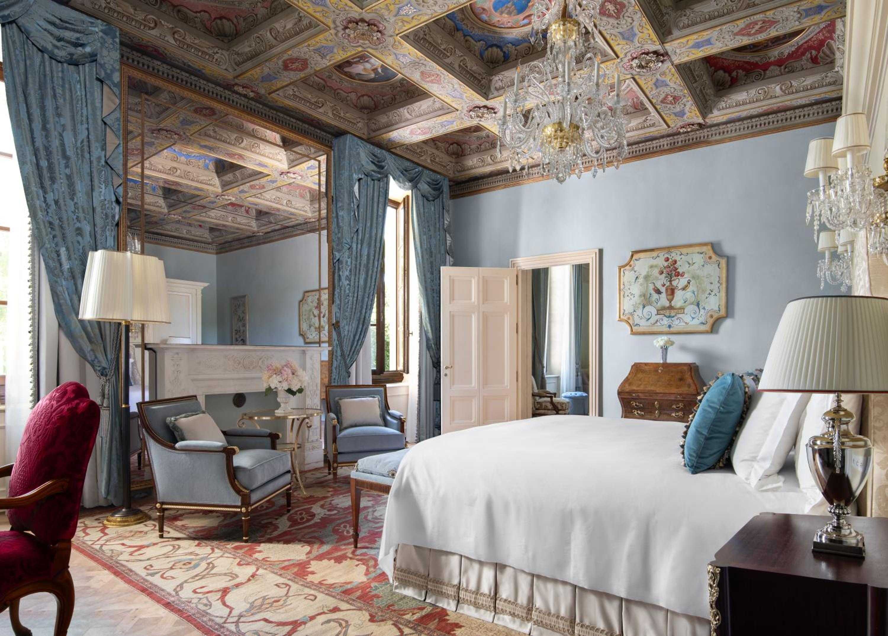 Frescoed ceilings and crystal chandeliers crown this palatial suite, where hand-painted details and azure silk curtains create an atmosphere of Renaissance grandeur.