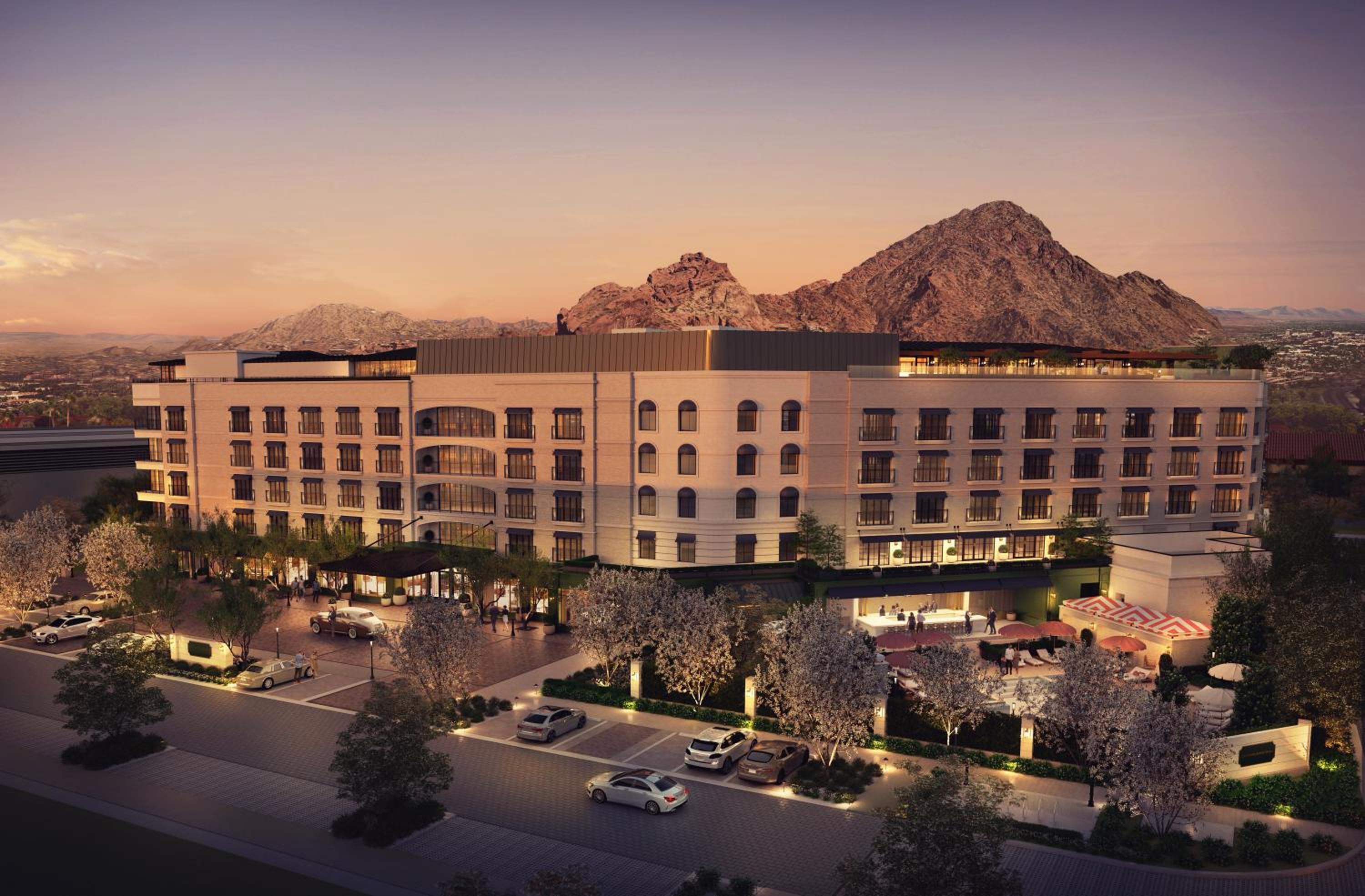 Golden hour illuminates the contemporary facade as desert mountains create a dramatic backdrop, while the thoughtfully landscaped entrance promises sophisticated hospitality within.