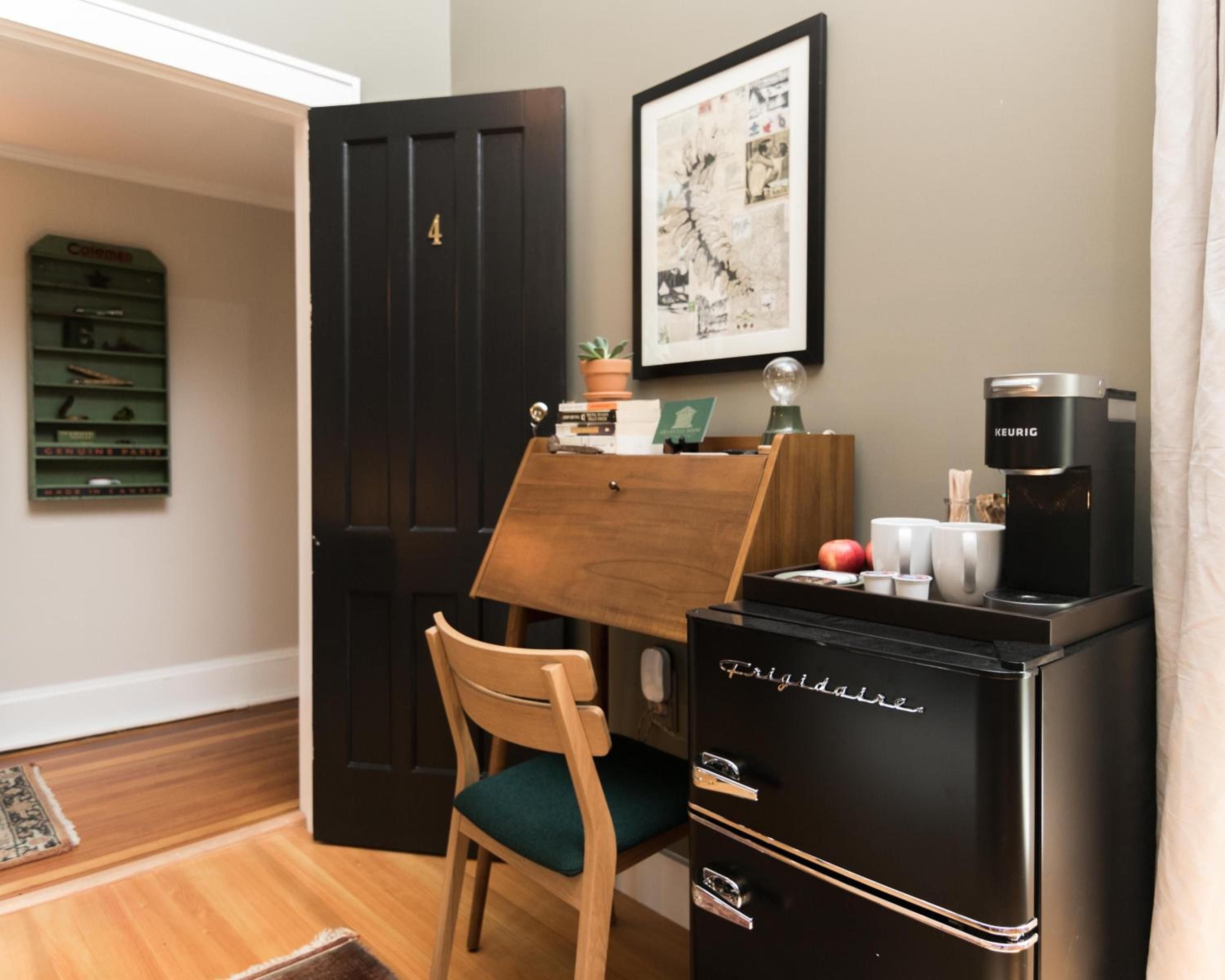Mid-century charm meets modern comfort in this thoughtfully curated corner, where vintage Frigidaire styling and warm wood tones create an inviting workspace.