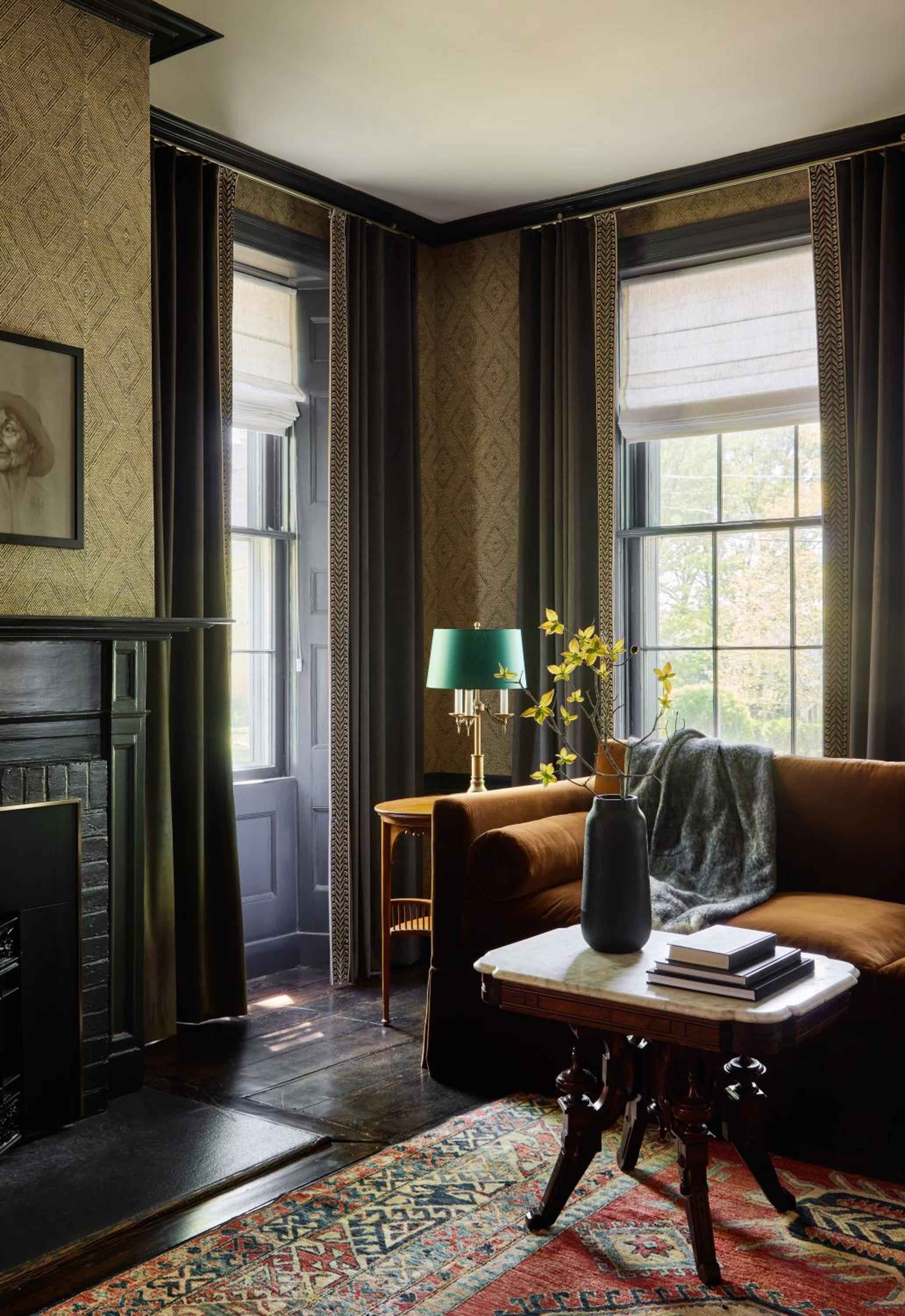 Rich textures and warm earth tones create an intimate corner where brass lamplight dances across weathered leather, inviting guests to settle in with a good book.