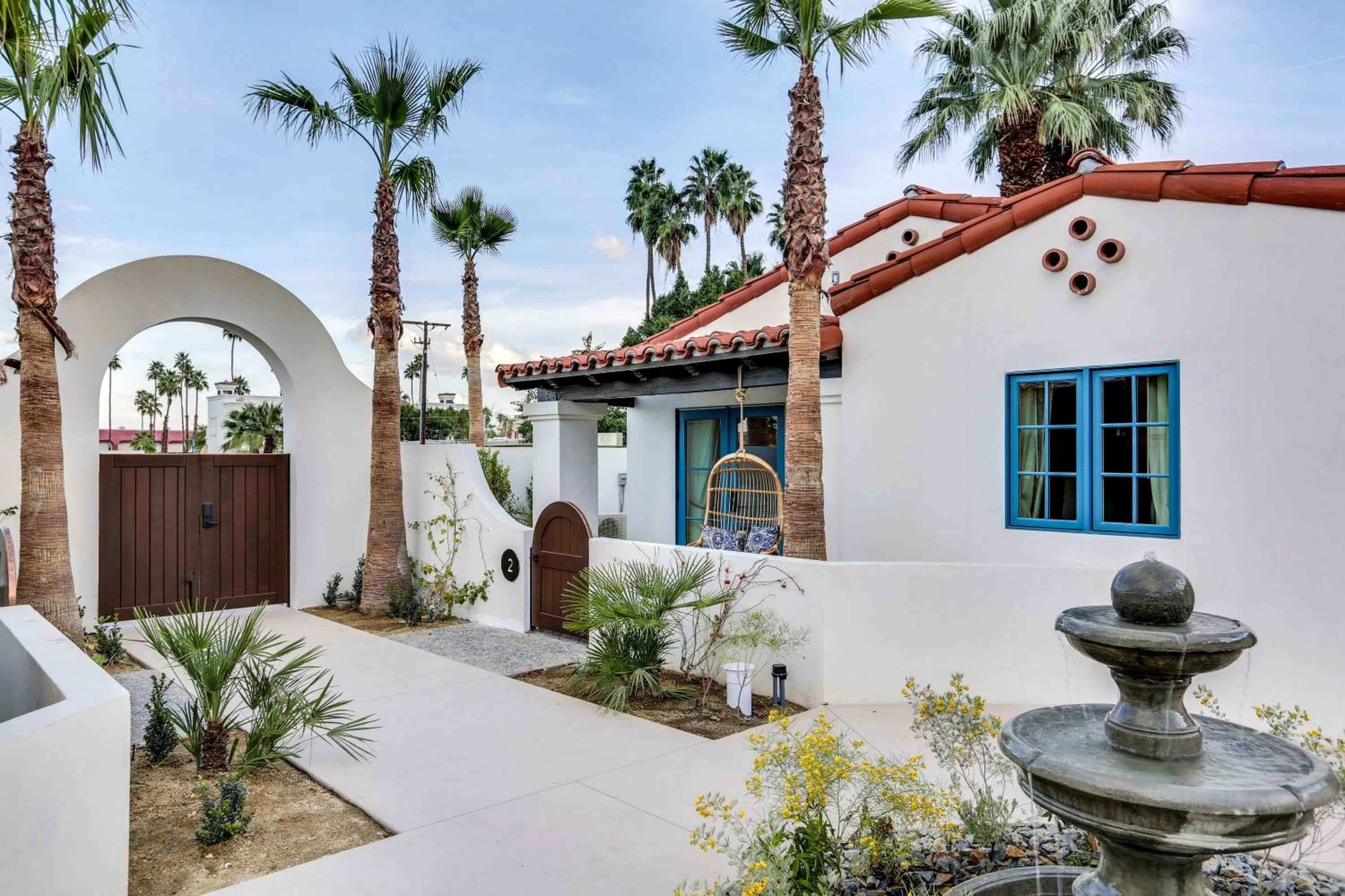 Spanish Colonial Revival architecture meets desert modernism in this intimate courtyard, where terracotta tiles, arched doorways, and swaying palms create a secluded Palm Springs sanctuary.