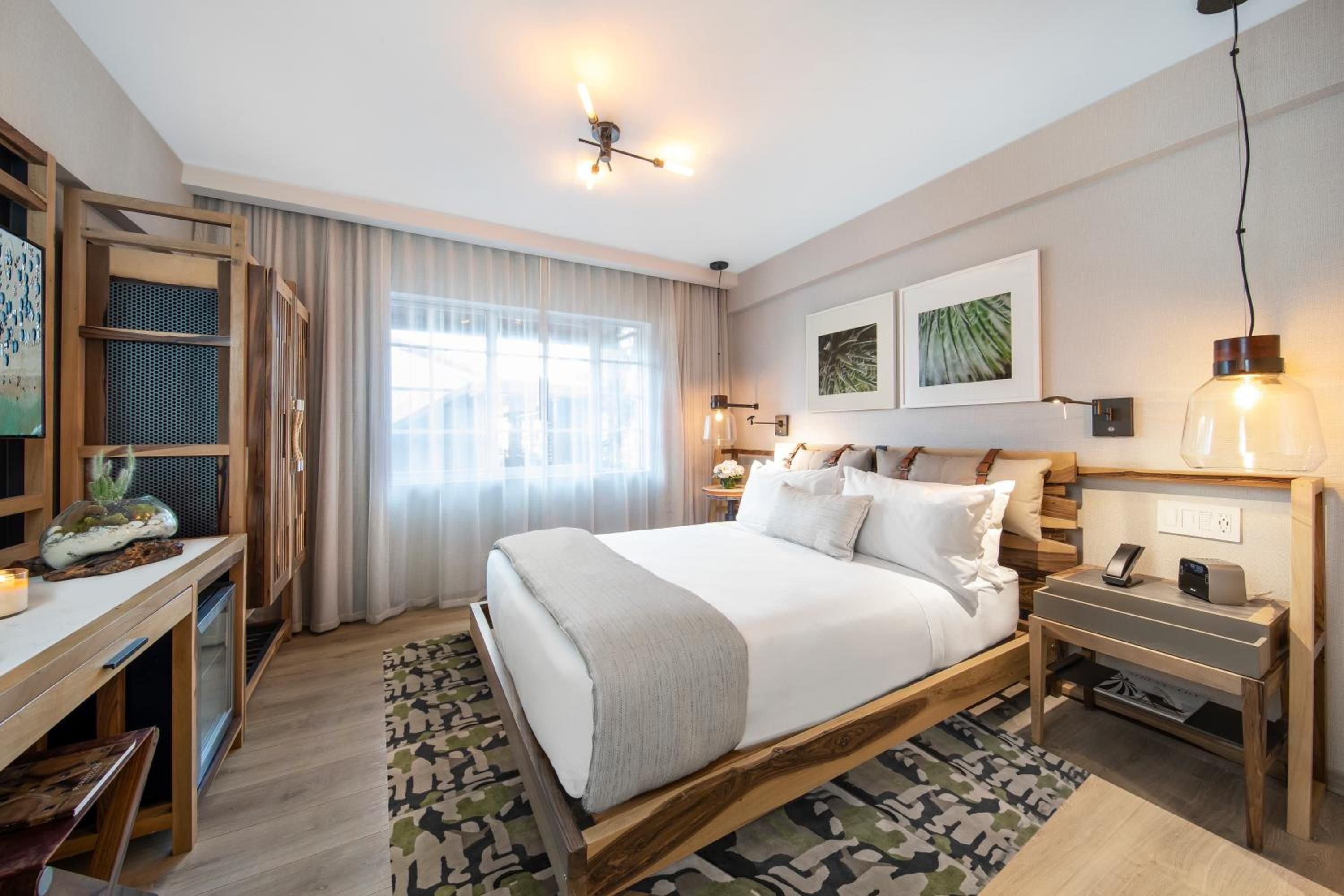 Natural wood tones and geometric patterns create a serene retreat, where filtered Miami light dances across crisp linens and thoughtfully curated botanical artwork.