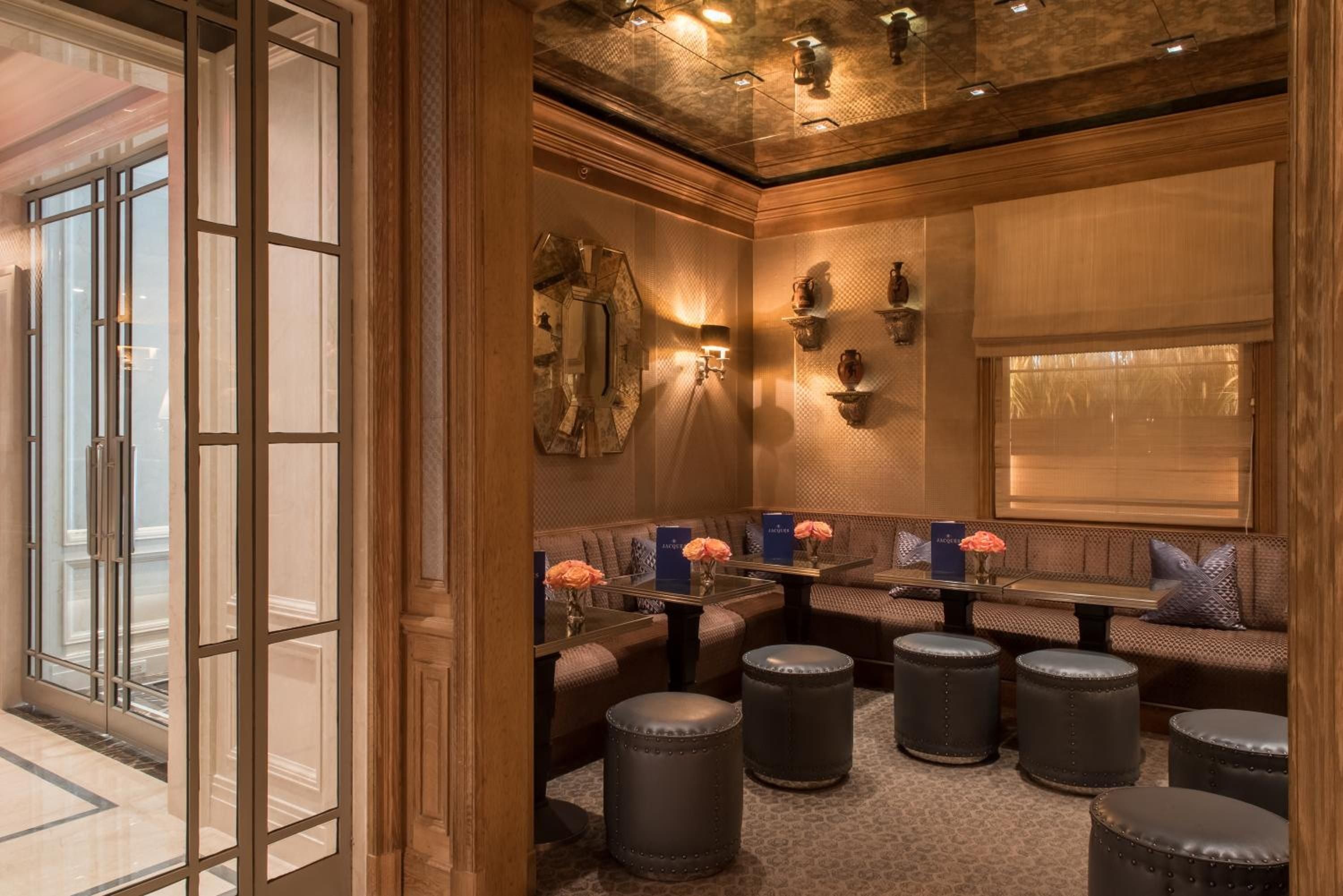Warm wood paneling and intimate banquette seating create a sophisticated retreat, where brass accents catch golden light and fresh blooms add unexpected softness to masculine elegance.