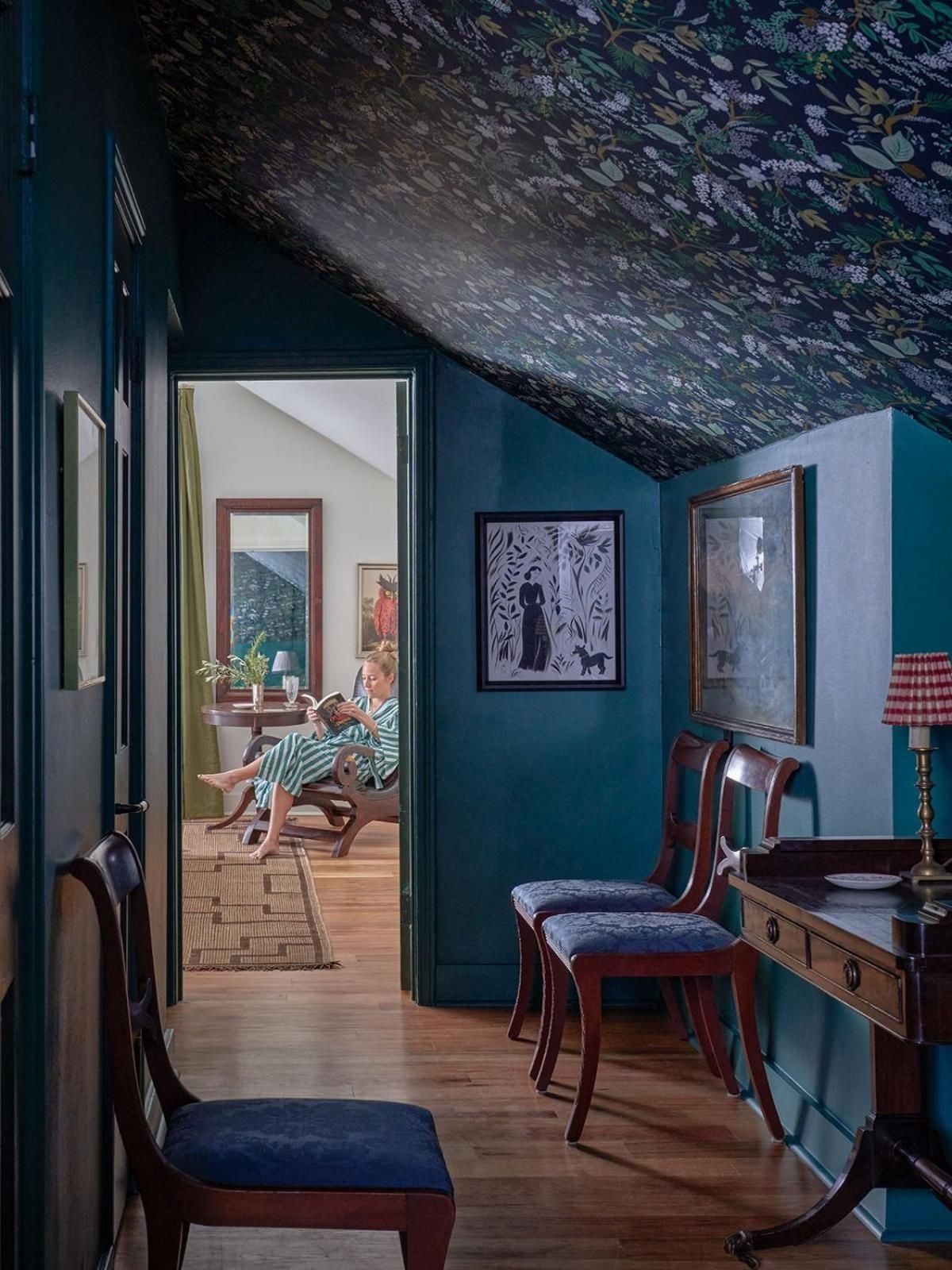 Bold teal walls and botanical ceiling wallpaper create an intimate study nook, where mahogany furniture and navy velvet cushions invite quiet moments between exploring the French Quarter.