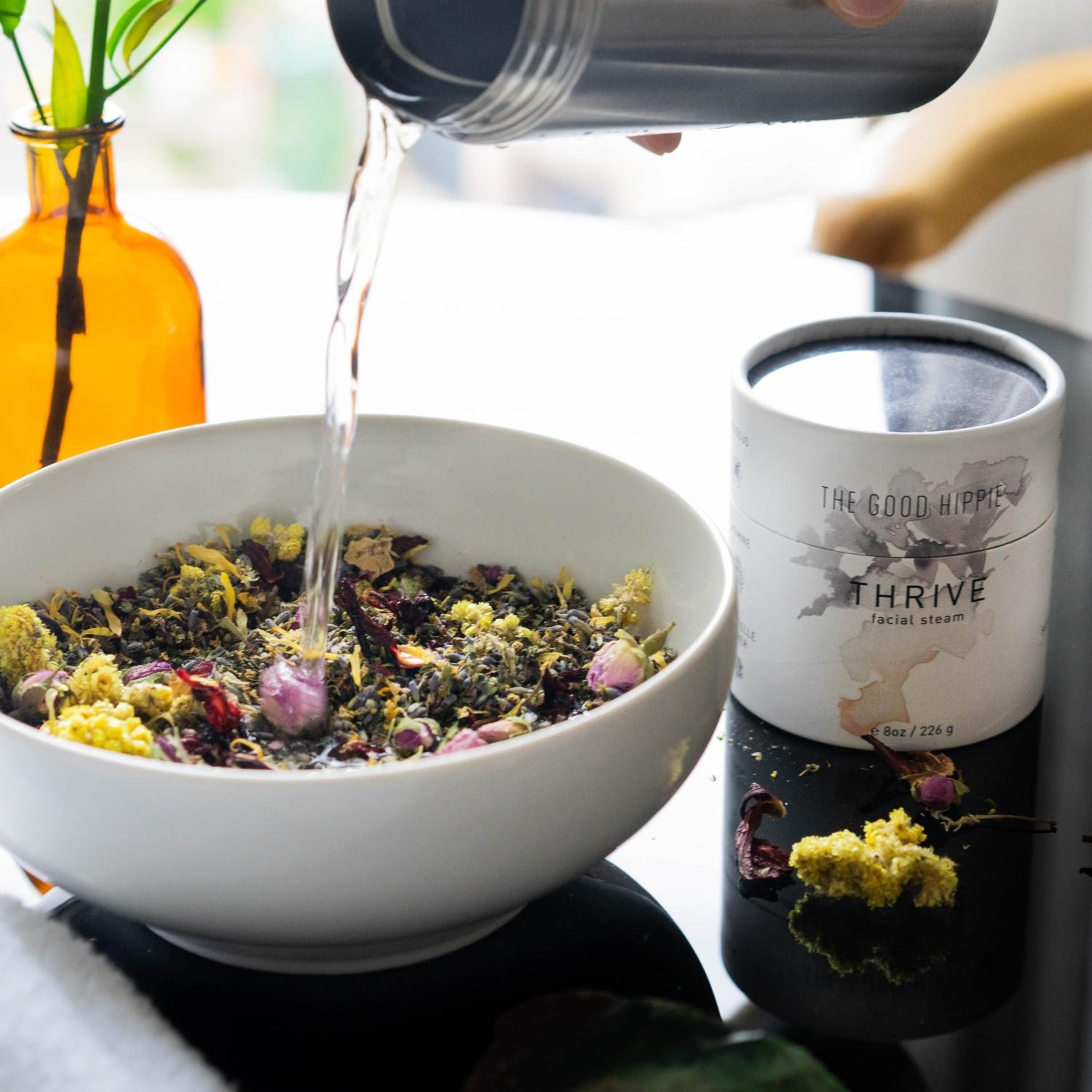 Herbal botanicals steep in ceramic bowls as steam rises, creating an aromatic ritual that transforms a simple facial treatment into sensory meditation.