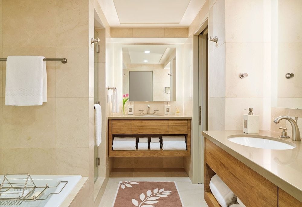 Warm wood vanities and creamy marble create a spa-like sanctuary where oversized soaking tubs and rainfall showers invite lingering moments of mountain luxury.