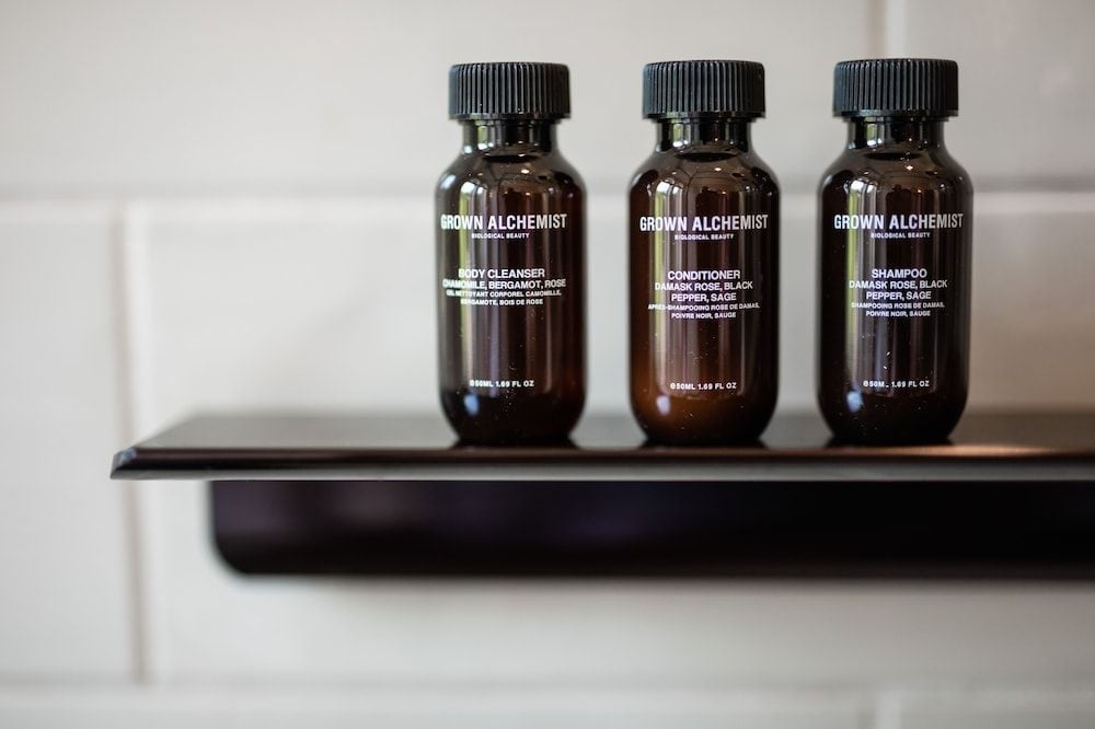Grown Alchemist's botanical toiletries rest on polished surfaces, their amber glass bottles promising a luxurious ritual of bergamot, rose, and sage.