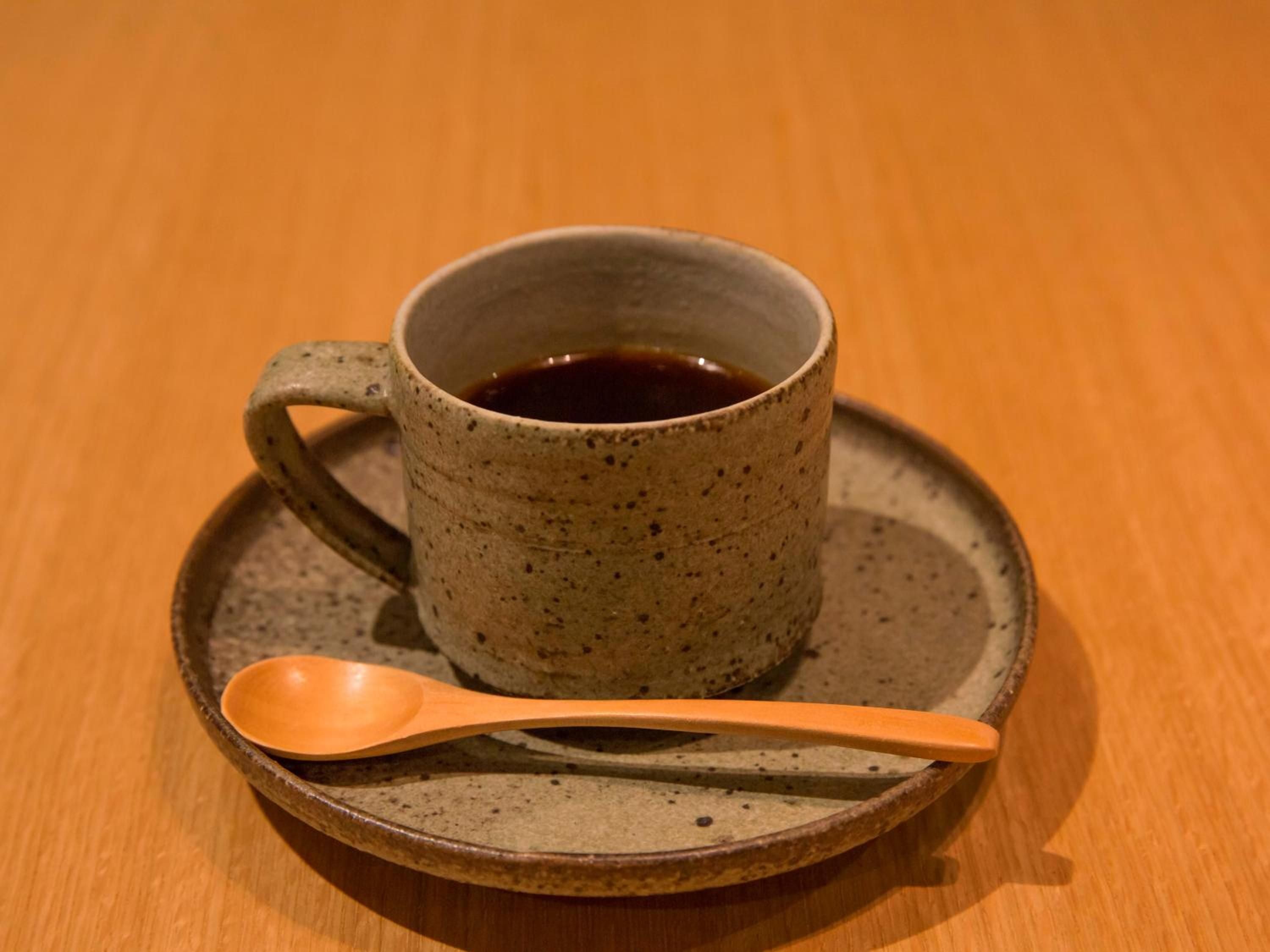 Handcrafted ceramic meets minimalist Japanese aesthetics in this artisanal coffee service, where speckled earthenware and warm wood create an intimate ritual of slow hospitality.