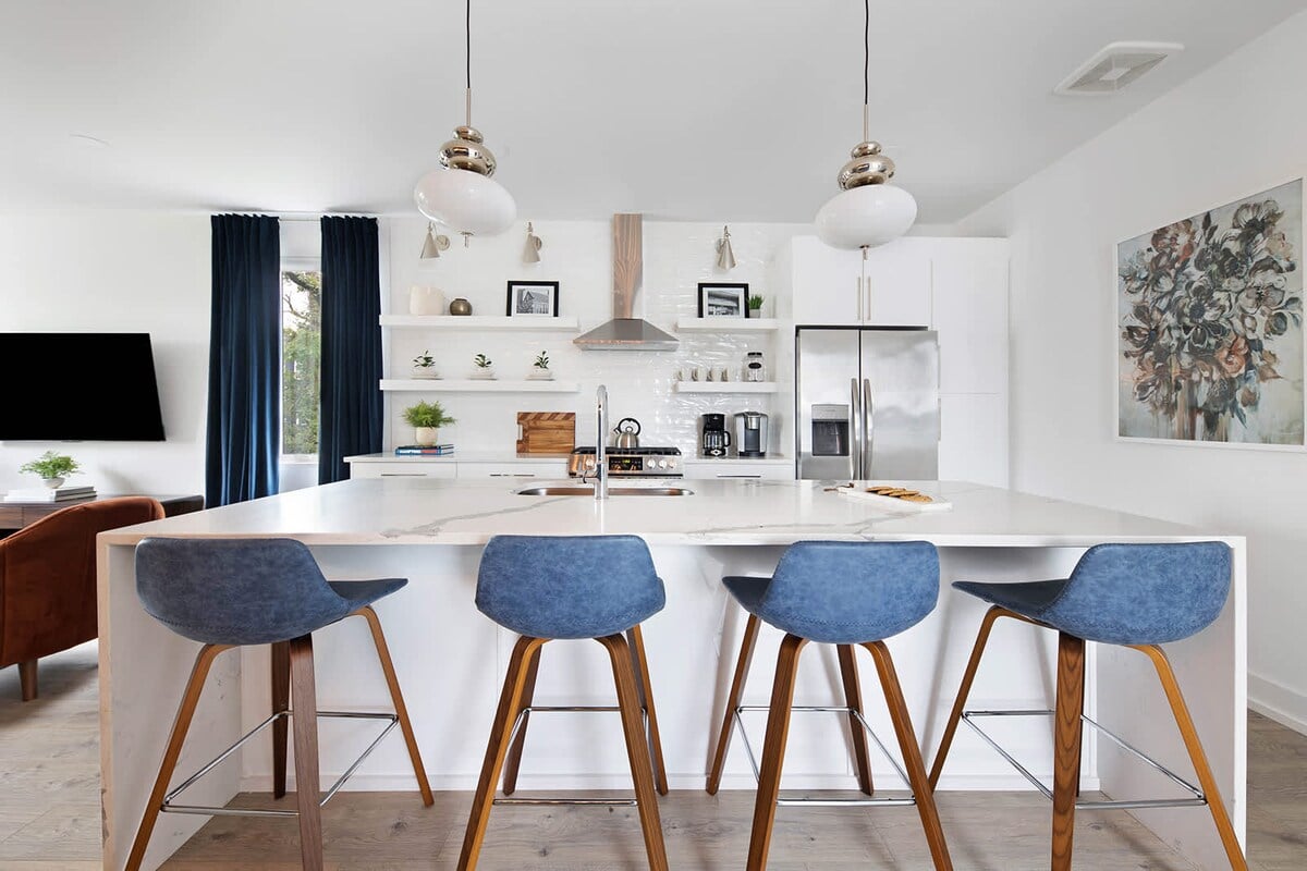 Clean and Spacious Kitchen with Sleek Countertops and Additional Seating