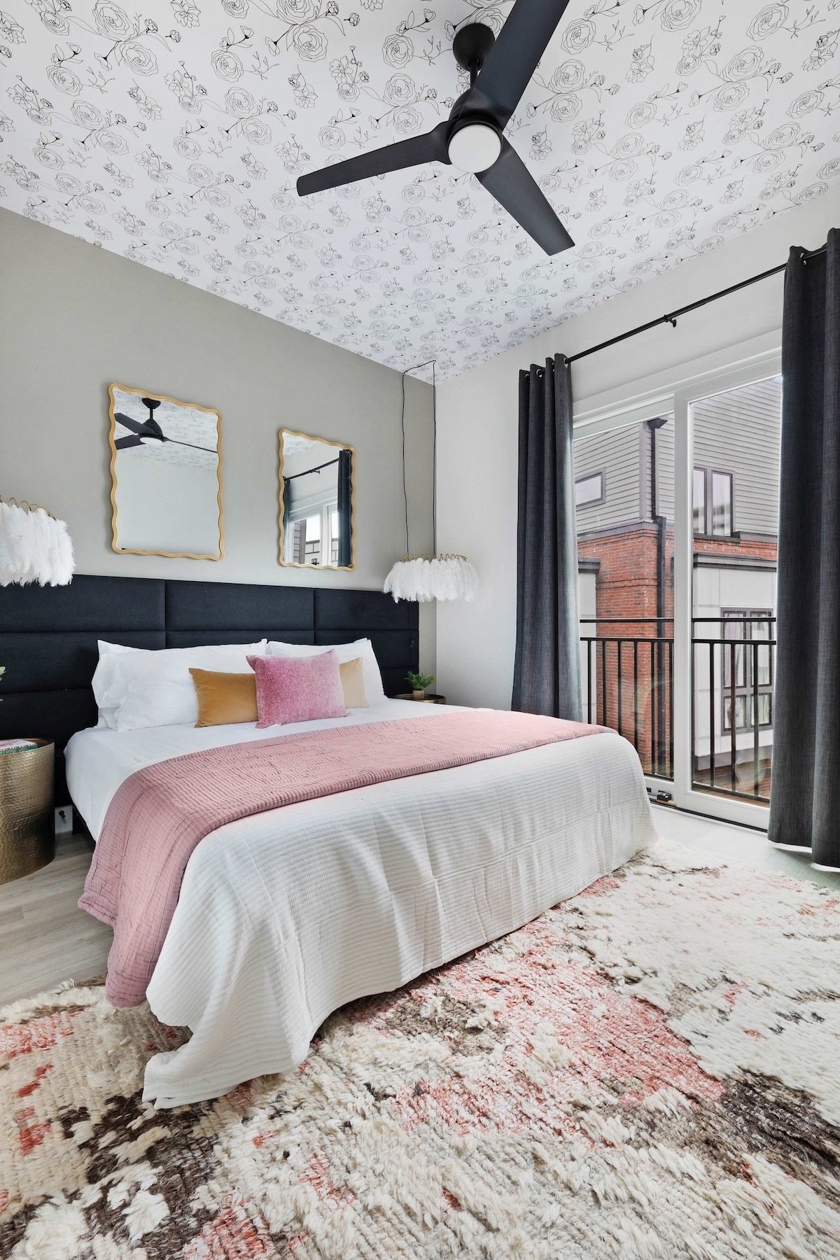 Elegant bedroom with a king bed, walk-in closet, and a private balcony featuring two chairs. The en-suite bathroom includes a modern shower for your comfort.