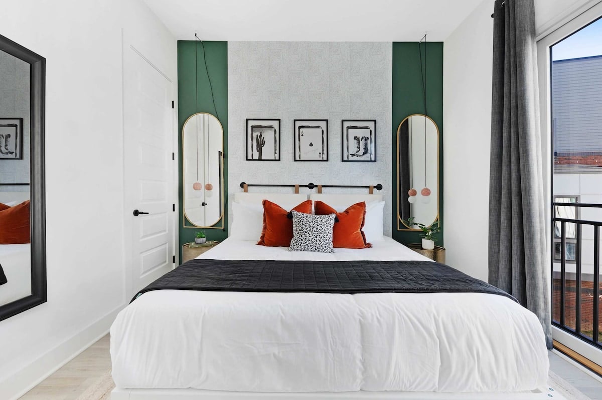 Relaxing bedroom with a king bed, walk-in closet, and an en-suite bathroom featuring a shower/tub combo, with dual access from both the bedroom and kitchen