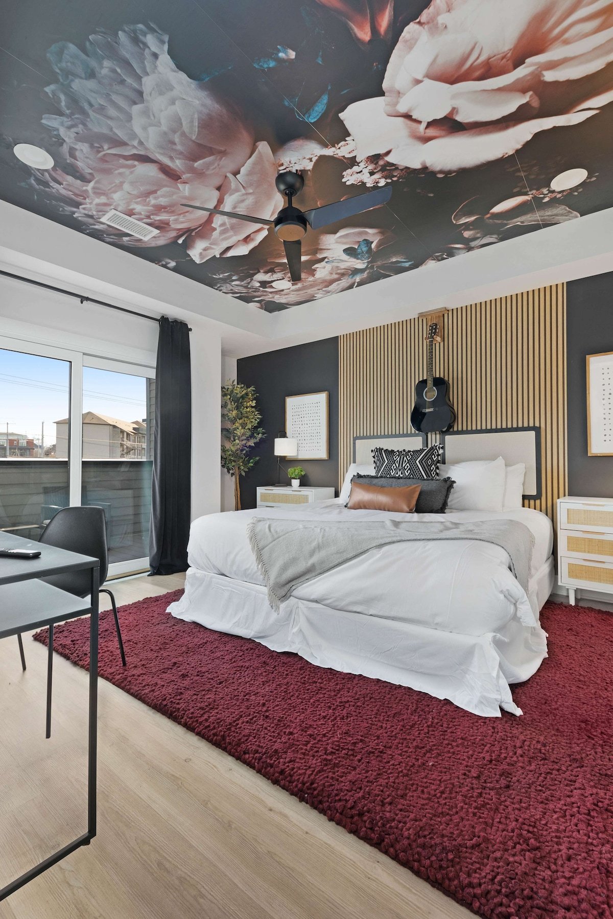 Serene bedroom with a king bed, walk-in closet, and a private balcony with two chairs. The en-suite bathroom features a modern shower for a refreshing experience.