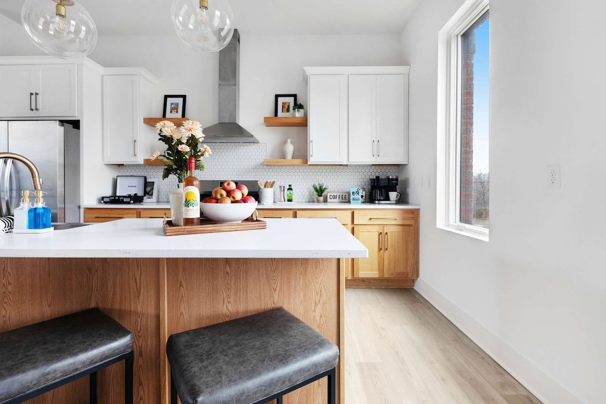 Clean and Spacious Kitchen with Sleek Countertops and Additional Seating