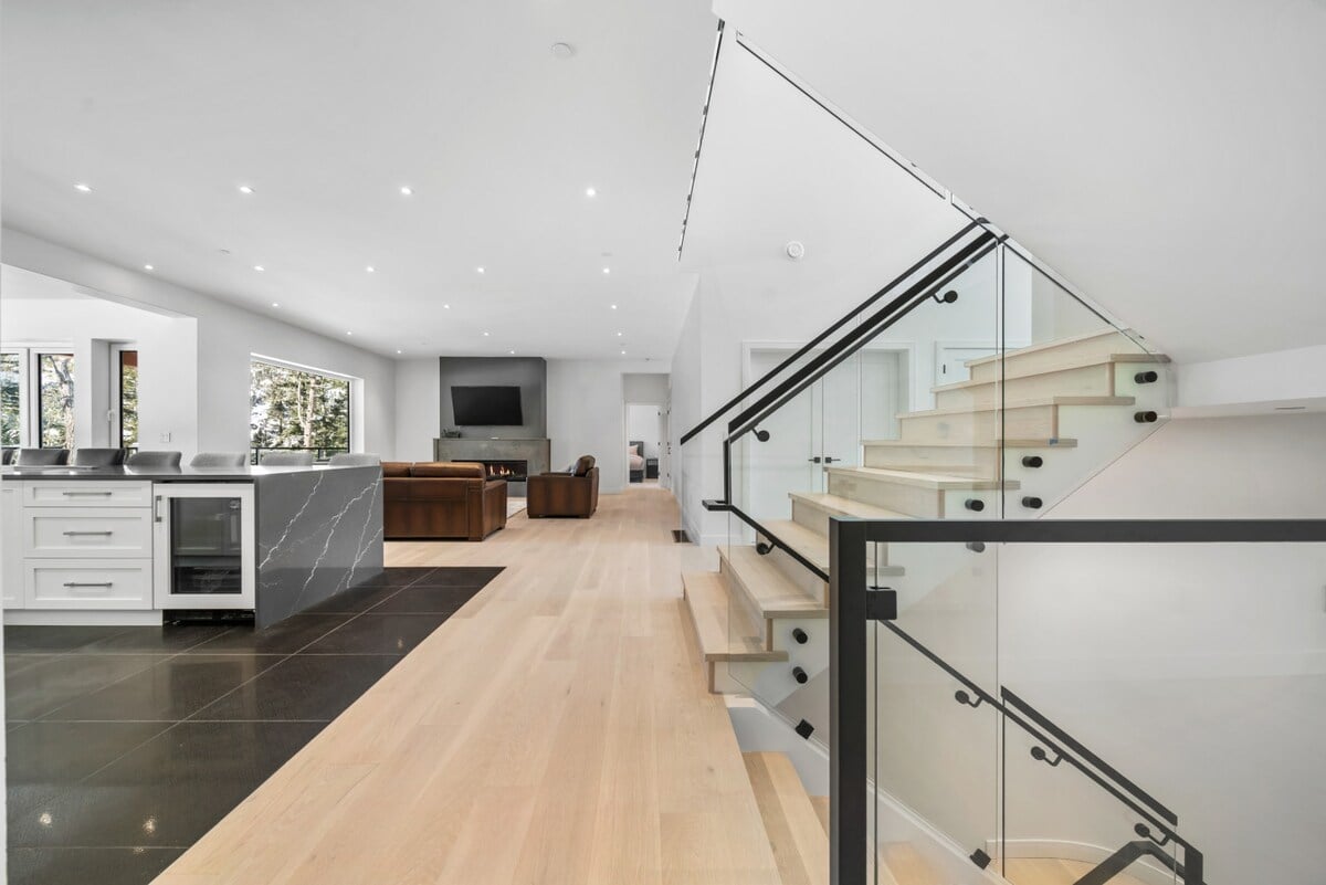 **CAPTION:** Experience modern luxury at "Property" in Squamish-Lillooet C, CA. This elegant estate boasts a contemporary architectural style with sleek lines and open spaces. The interior features a sophisticated black and white color palette, complemented by natural light pouring in through large windows. The inviting atmosphere is enhanced by plush seating and high-end finishes, appealing to discerning travelers seeking tranquility and style. Explore this serene retreat nestled in nature’s embrace.